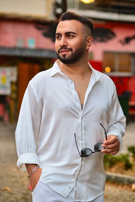 Nick Frazier, reviewer — professional headshot of a confident man in a white shirt holding sunglasses.