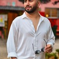 Nick Frazier, reviewer — professional headshot of a confident man in a white shirt holding sunglasses.