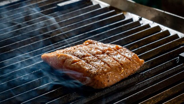 Salmon fillet sizzling on an outdoor grill