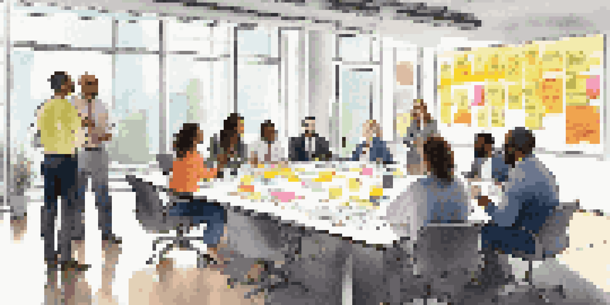 A group of diverse professionals in a bright conference room discussing transformation strategies with a whiteboard filled with notes.
