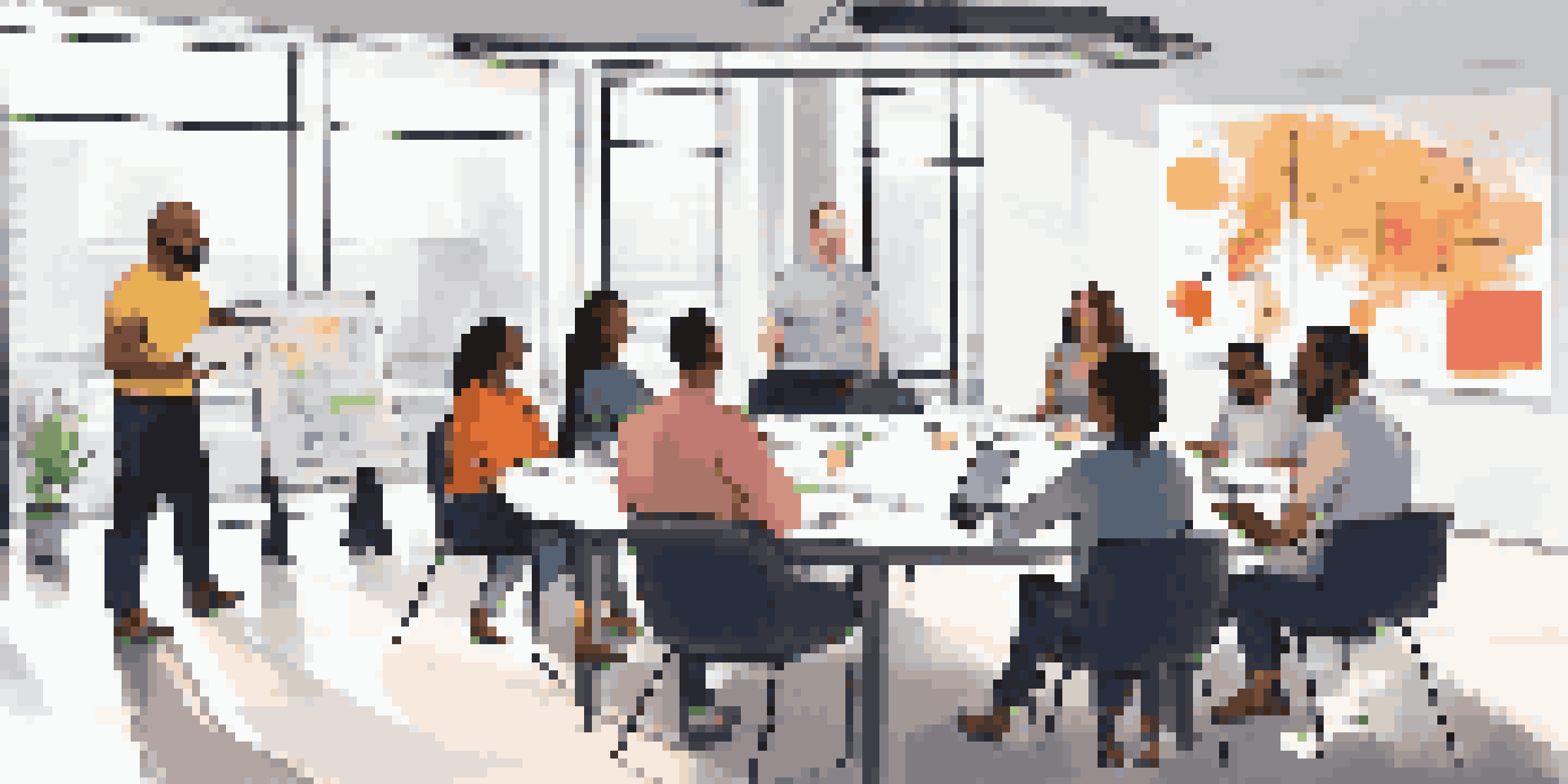 A diverse group of employees participating in a collaborative training session in a bright, modern office, sharing ideas around a round table with laptops and colorful charts on a whiteboard.