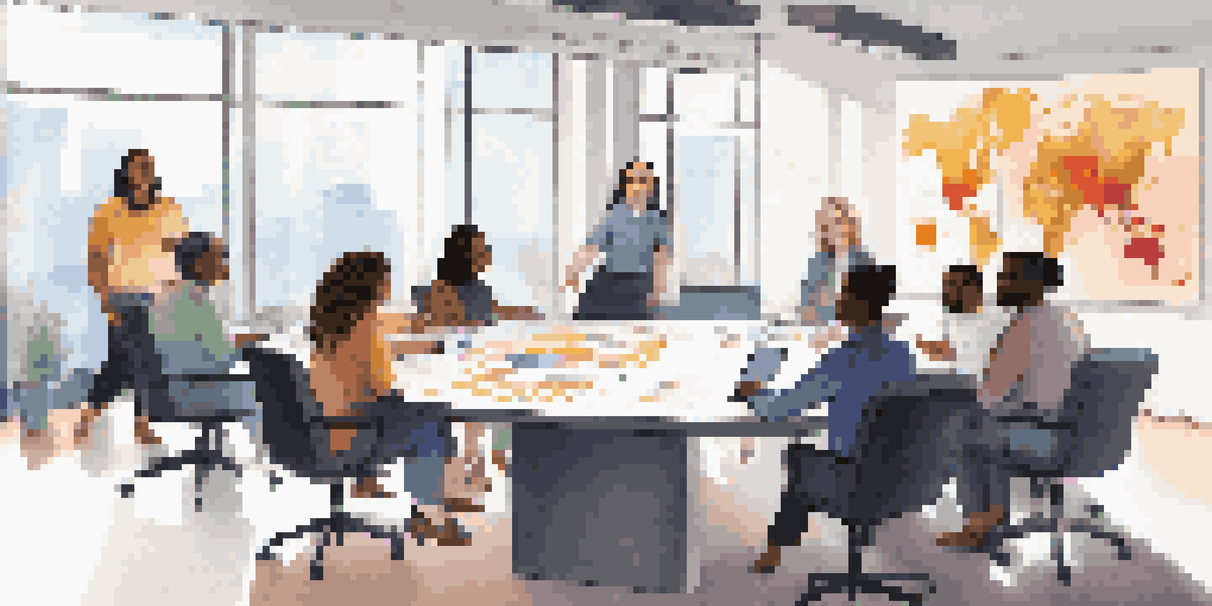 A diverse group of professionals in a modern meeting room, collaborating around a conference table with charts in the background.