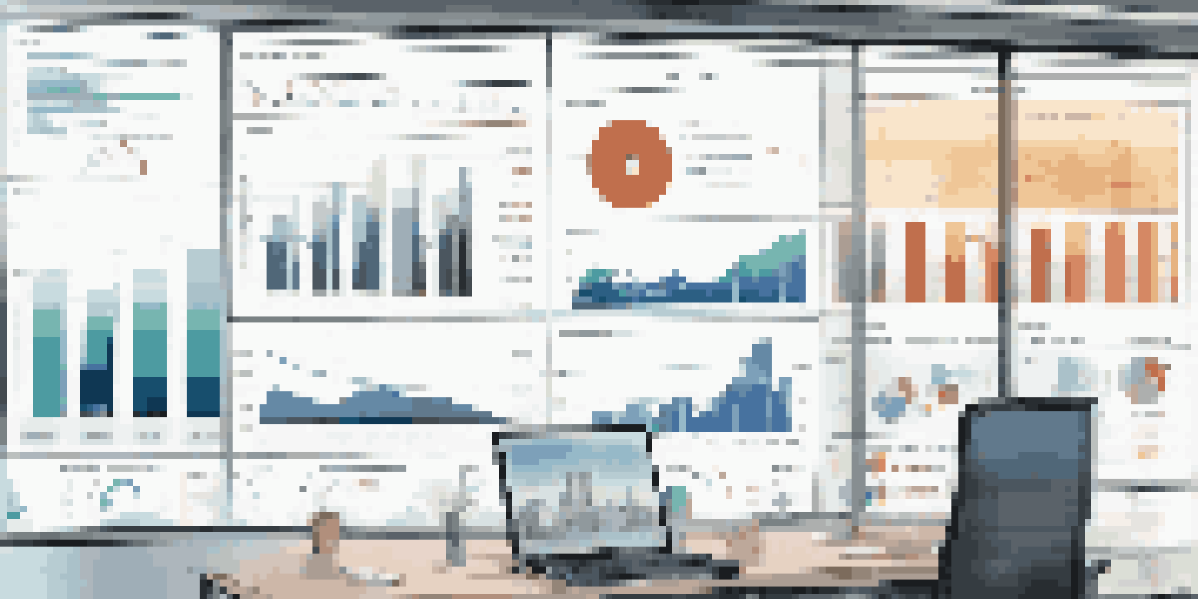 A modern business dashboard on a monitor showing colorful data visualizations in a bright office setting.