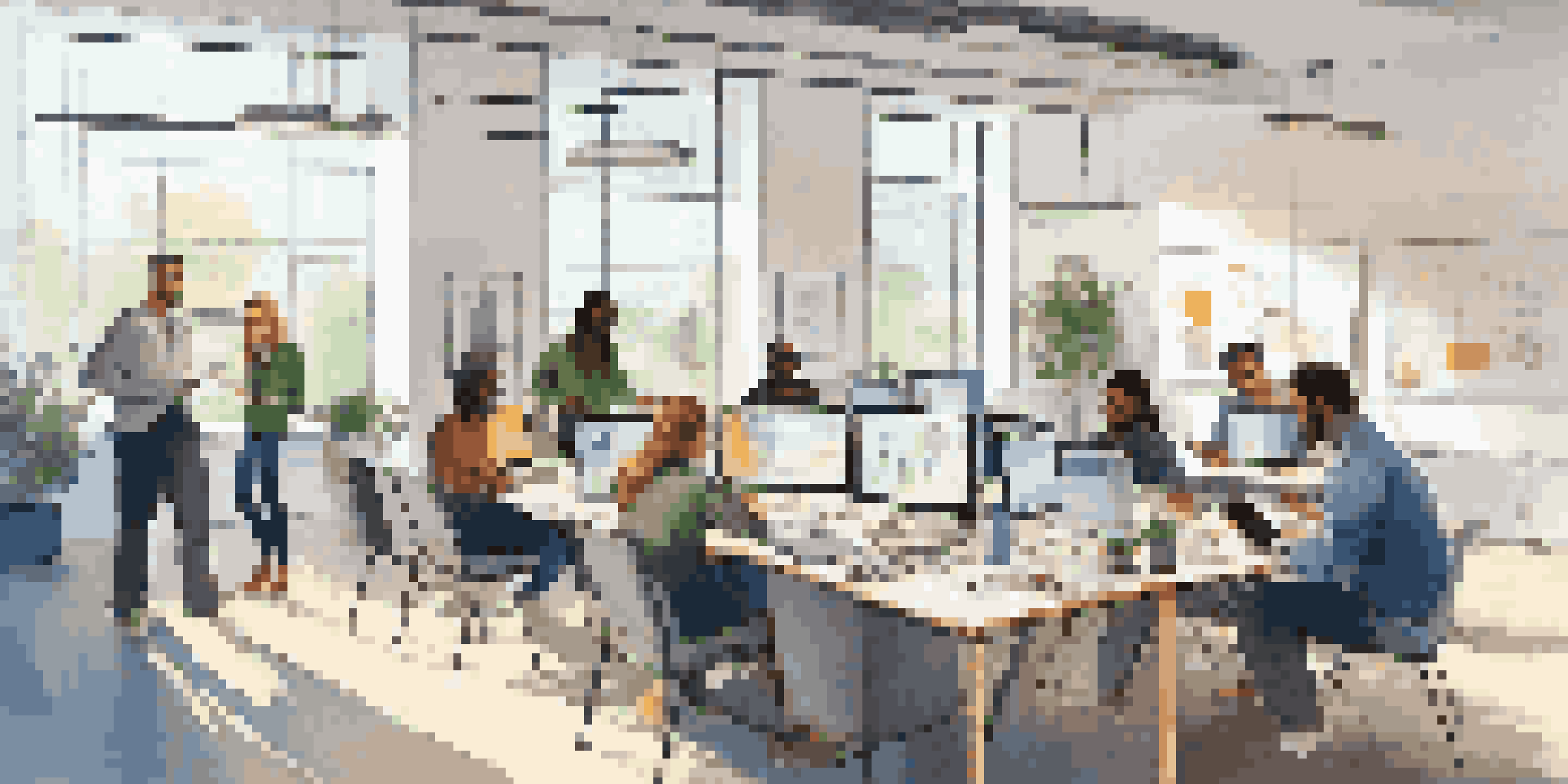 A diverse team in a modern office, actively collaborating and listening to each other around a large table, with bright natural light and a whiteboard filled with ideas in the background.