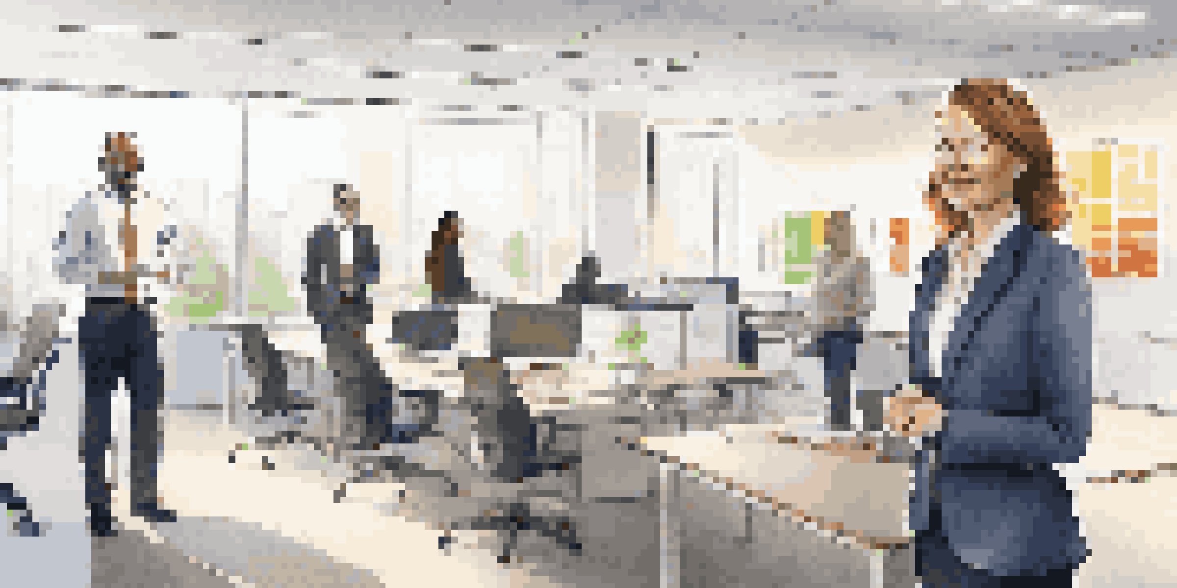 A change agent interacting with a diverse team in a bright, modern office, surrounded by charts and digital displays.