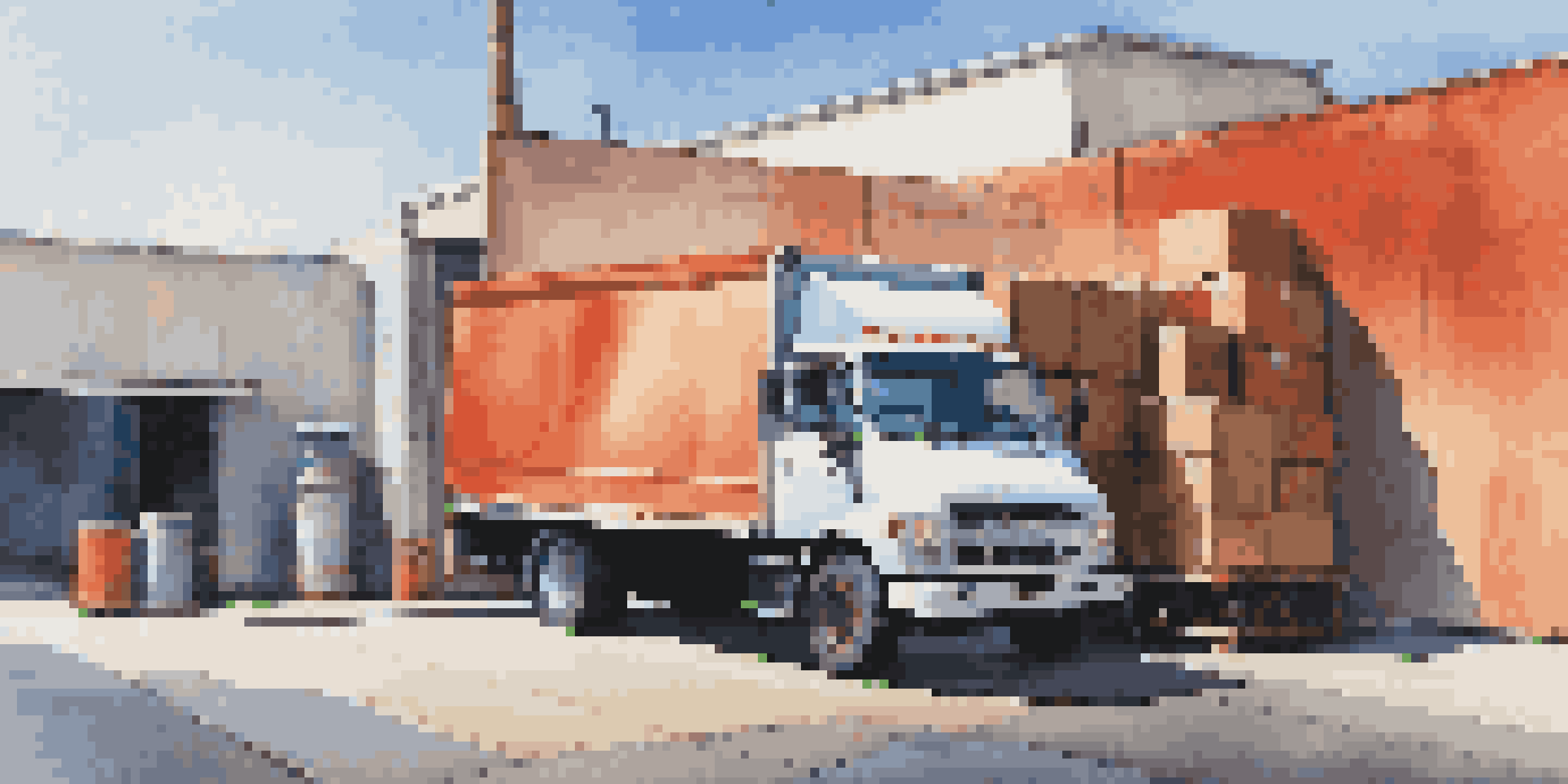 A colorful delivery truck parked at a loading dock with boxes being unloaded.