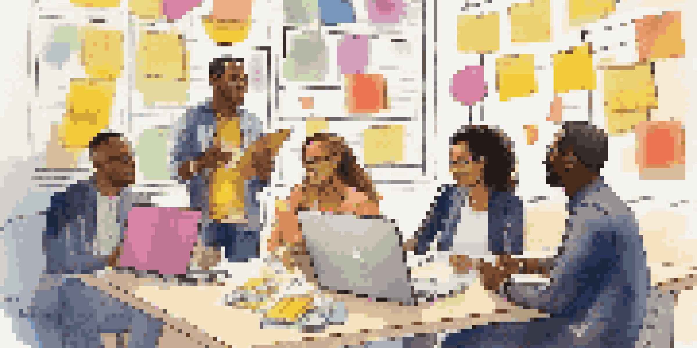 A diverse group of individuals brainstorming with colorful sticky notes and laptops in a well-lit environment.