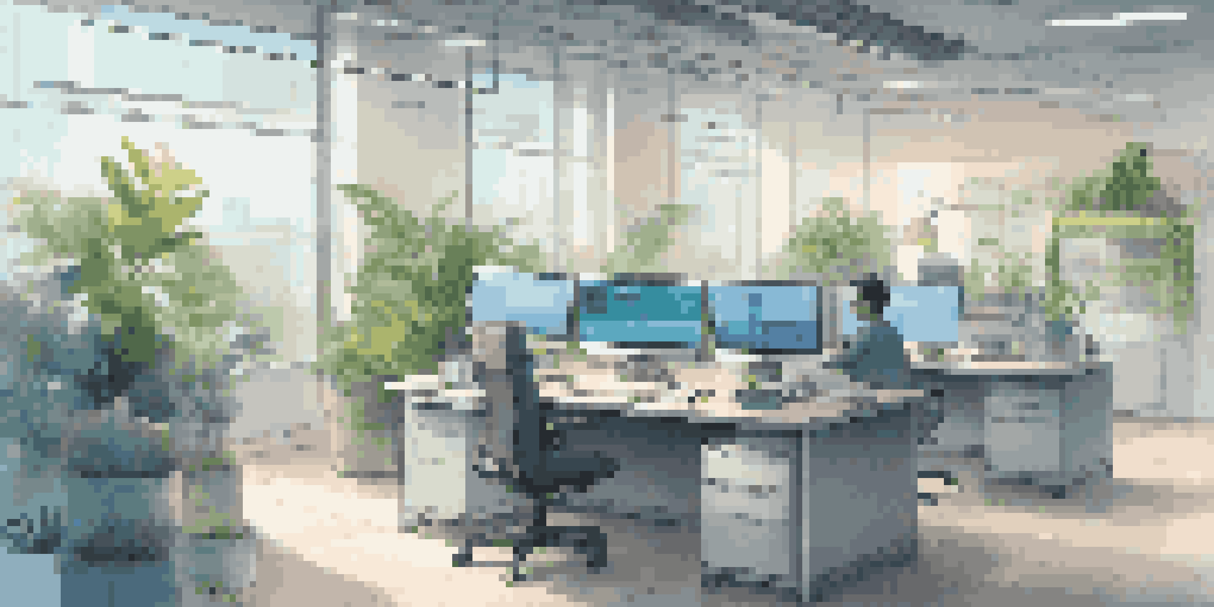 A contemporary office with a computer showing a chatbot interface, surrounded by greenery and natural light.