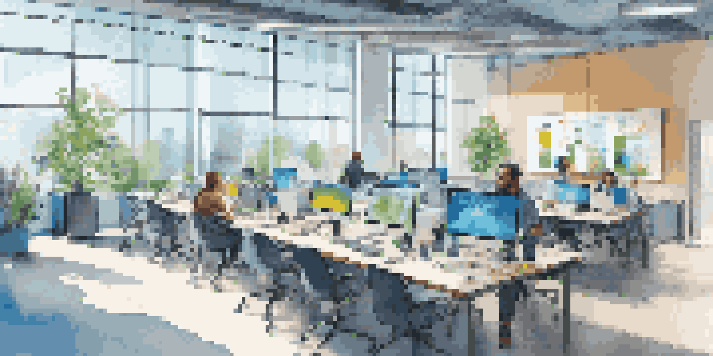 A bright open-plan workspace in a business accelerator with diverse entrepreneurs engaged in discussions and digital screens showing data analytics.