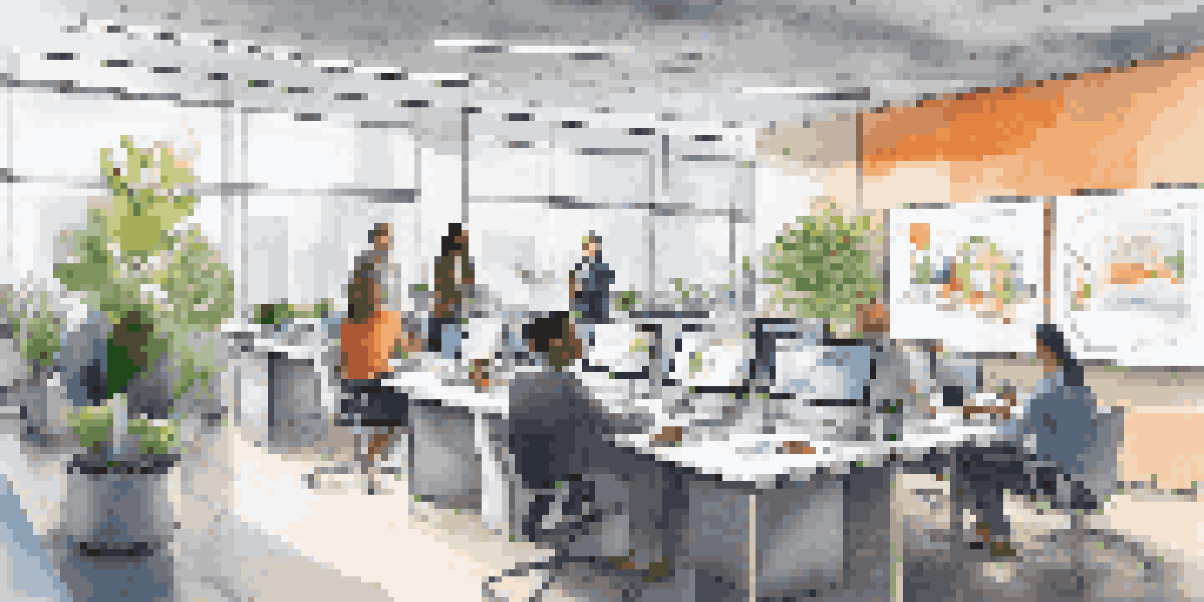 A diverse team of professionals in a bright office brainstorming with whiteboards and laptops around them.