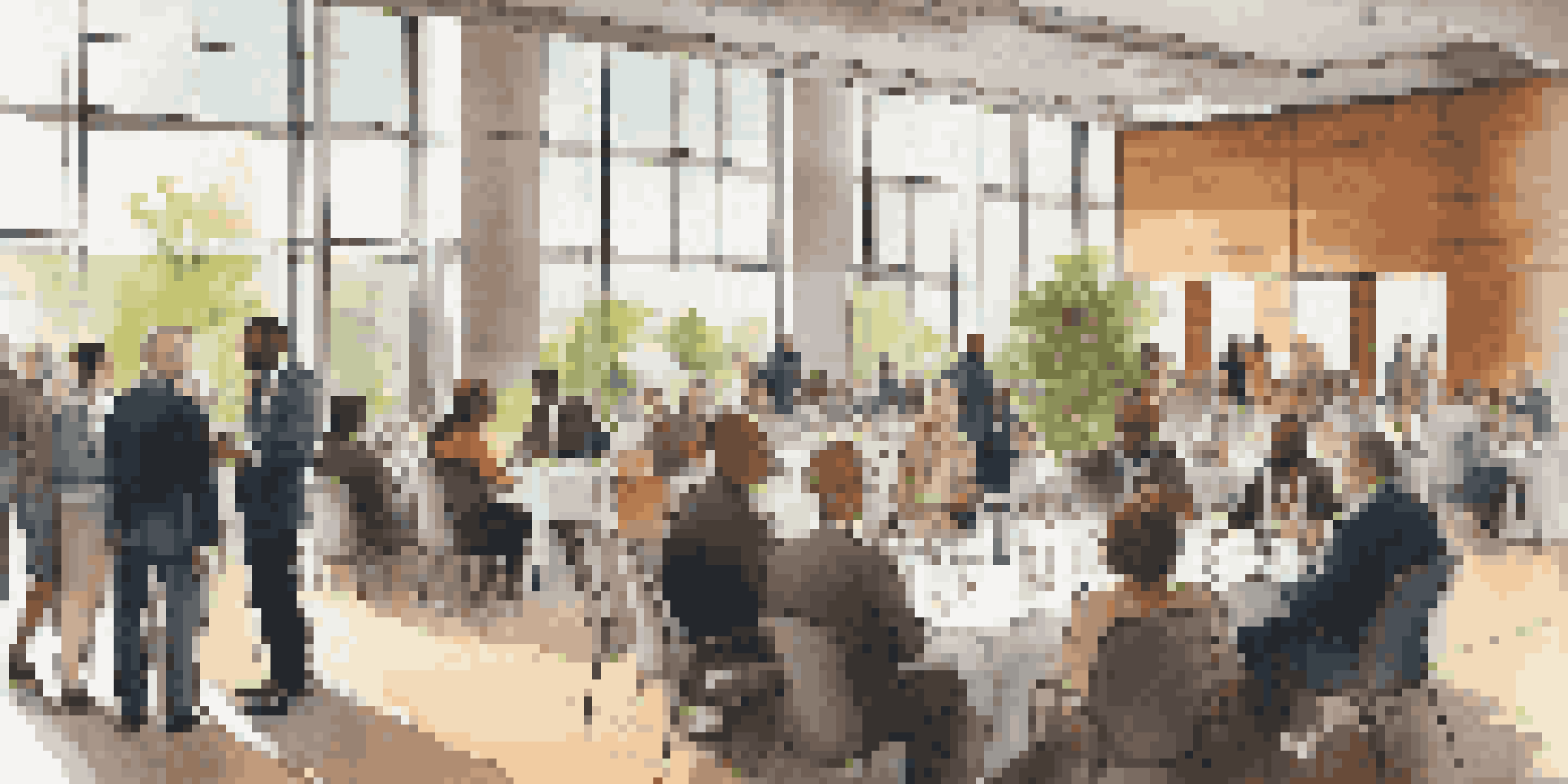 A modern networking event with diverse professionals in conversation, surrounded by booths and natural light.