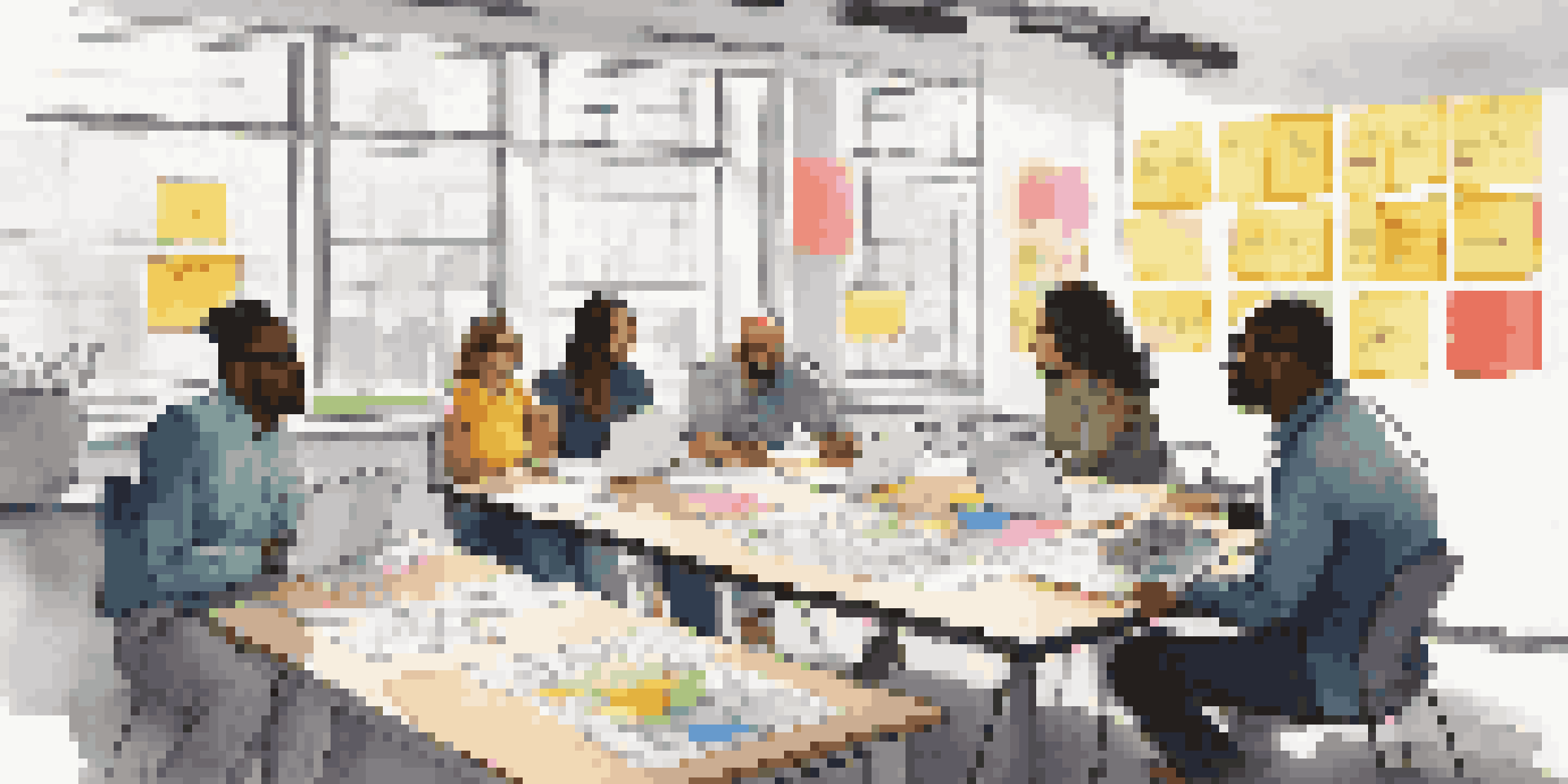 A diverse group of people in a workshop, discussing ideas with sticky notes and a whiteboard.