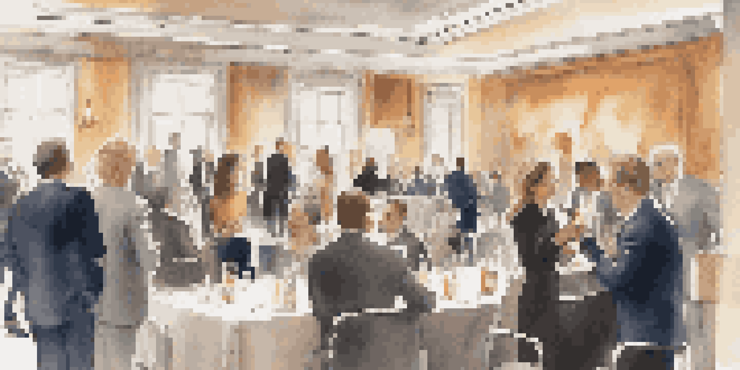 A bustling networking event with professionals in business attire engaging in conversation in a well-decorated conference room.