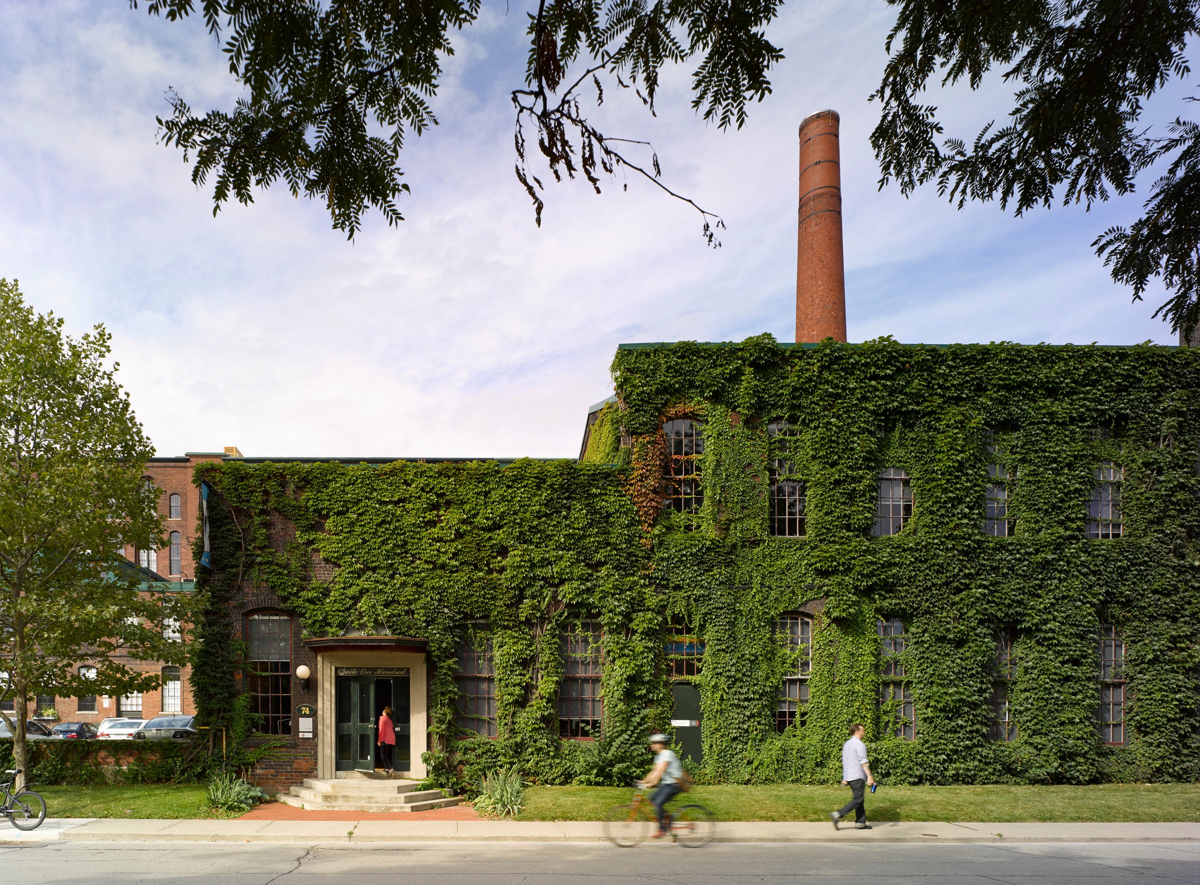 Ivy-covered brick factory with a smokestack