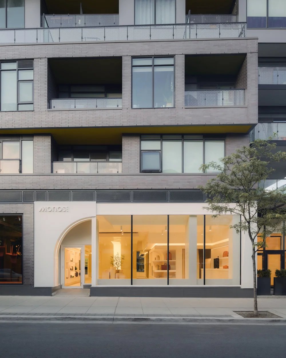 Lit ground-floor shop under a brick apartment block