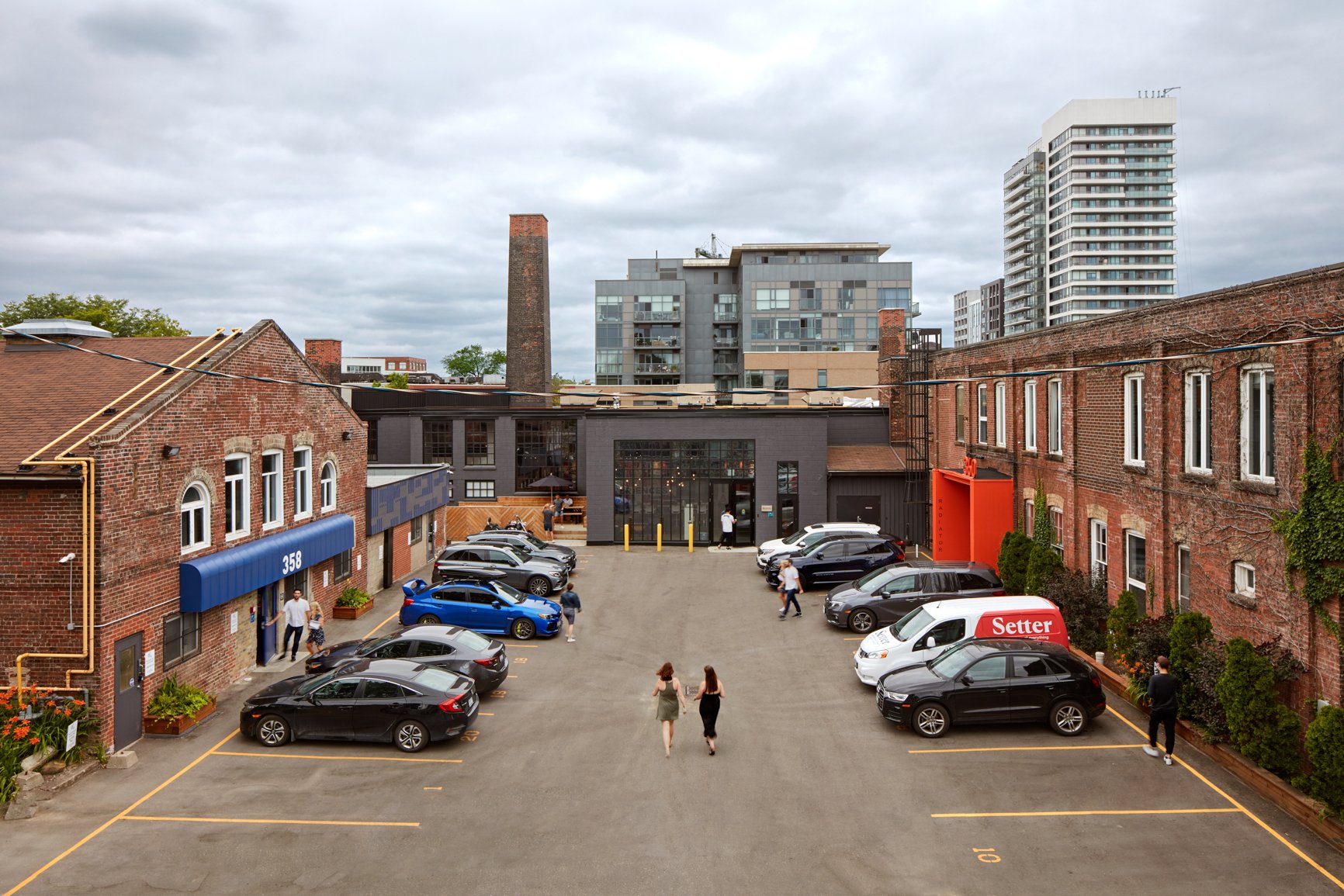 Brick warehouse courtyard with parked cars