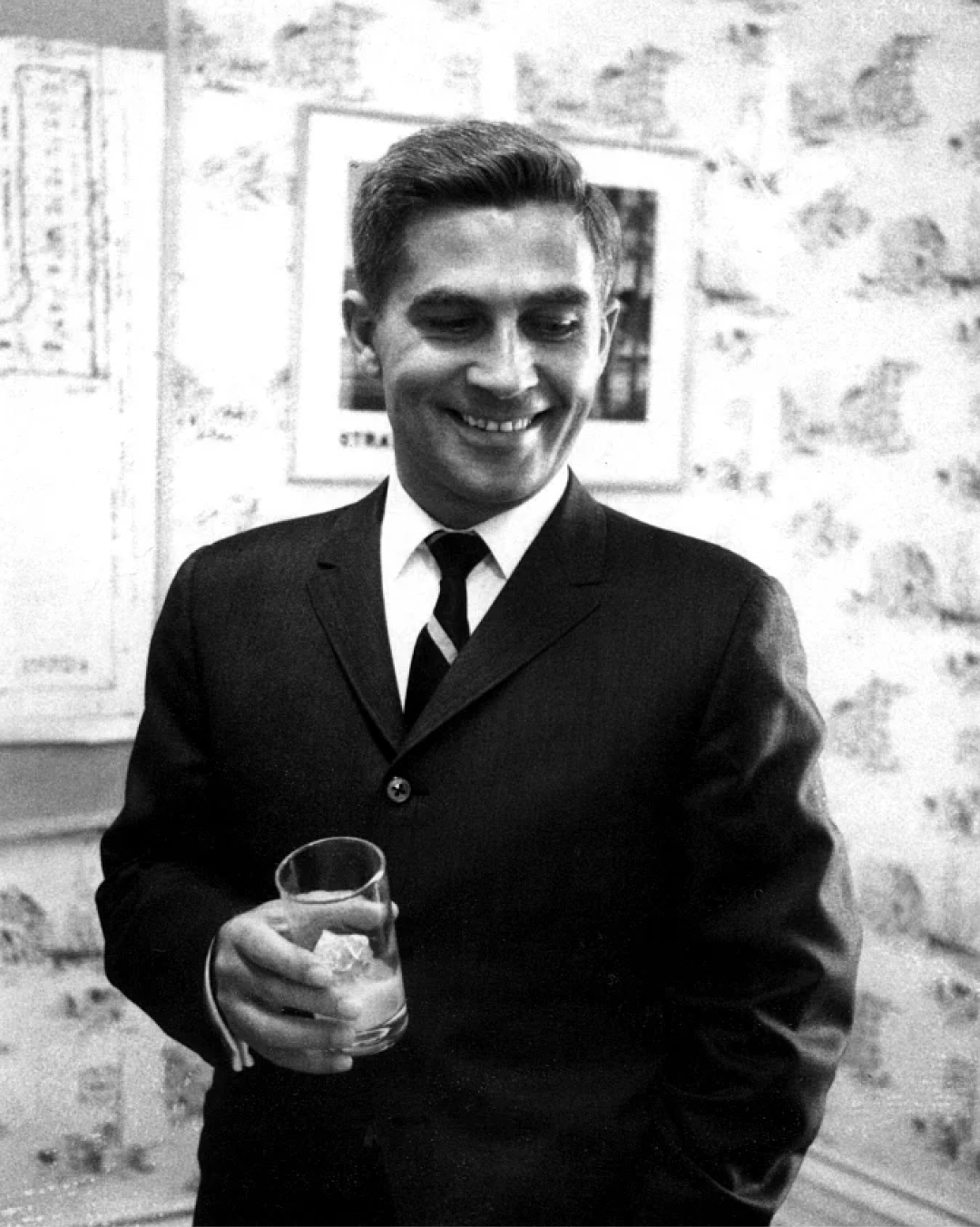 Archival photo of a man in a suit holding a glass