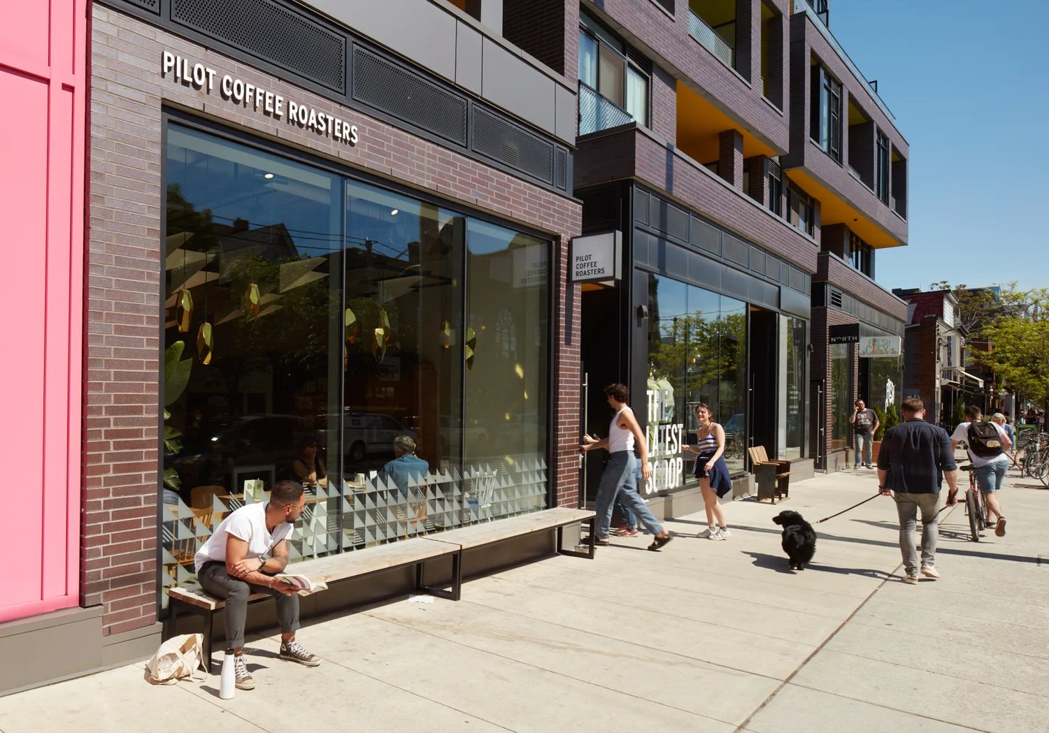 Cafe storefront with people on a sunny sidewalk