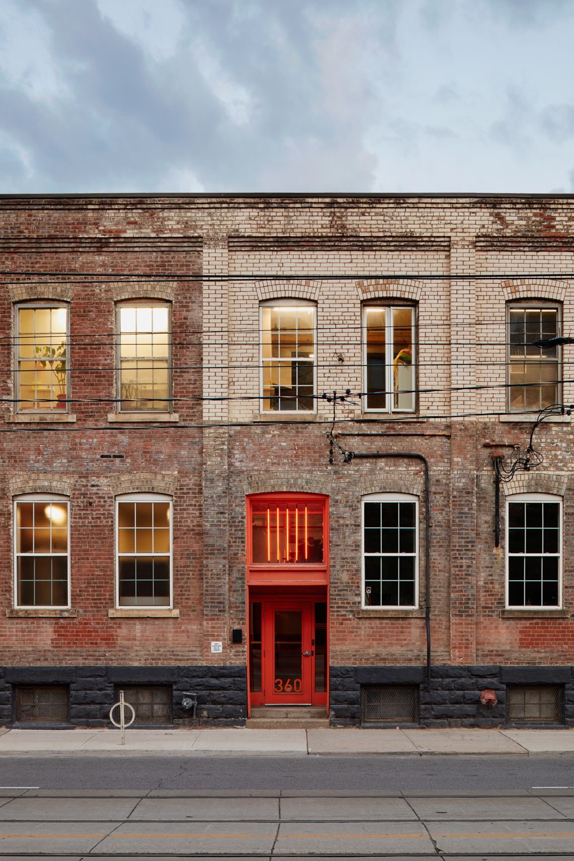 Brick loft facade with a red entry door