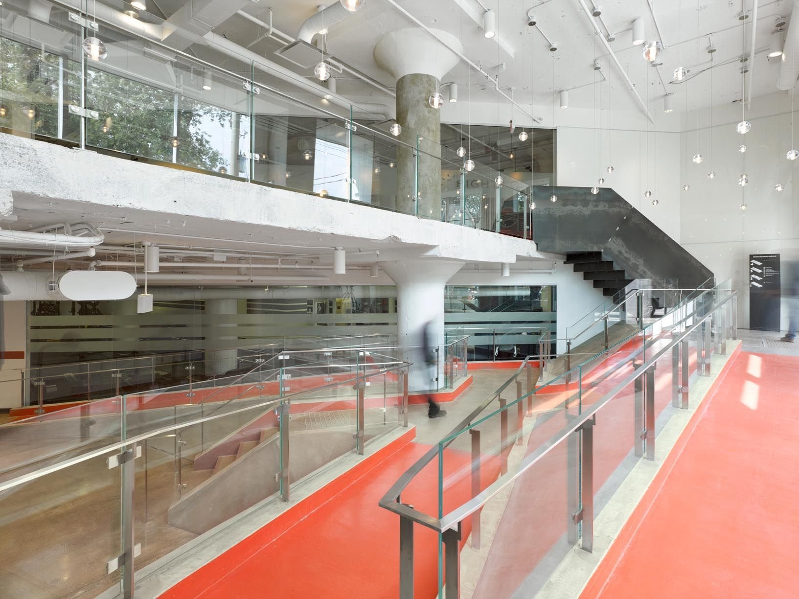 Lobby walkway with red floor and glass rails