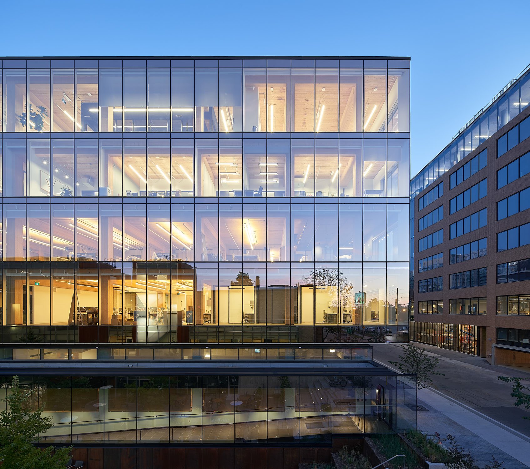 Glass office building lit up at dusk