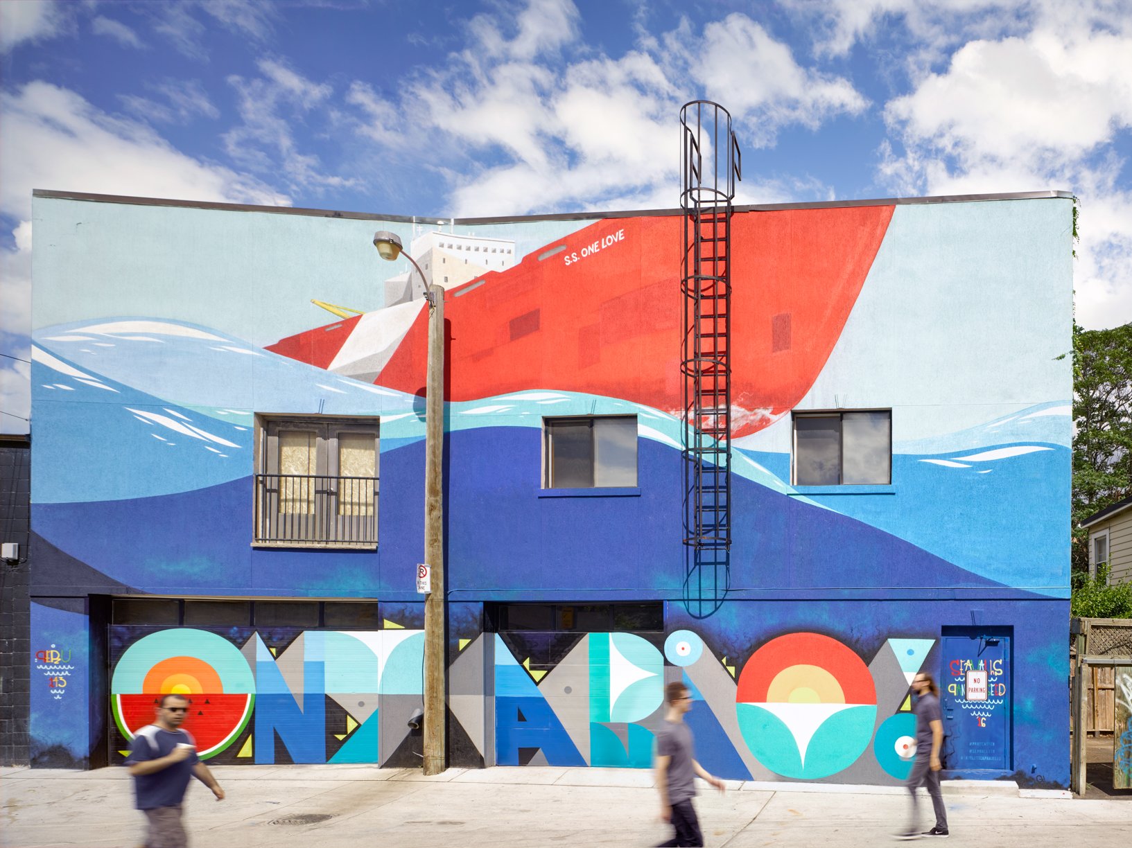 Bold wave mural on a low brick building