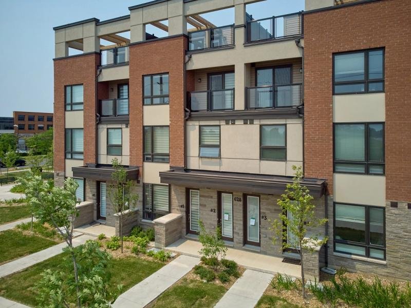 Brick and stucco stacked townhomes with balconies