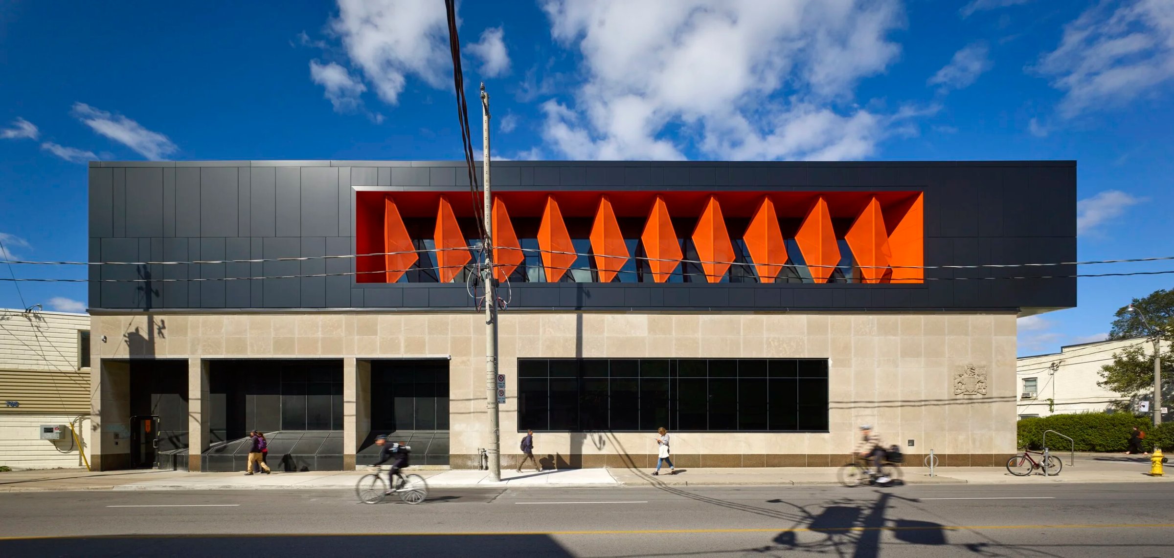 Dark clad building with orange folded panels