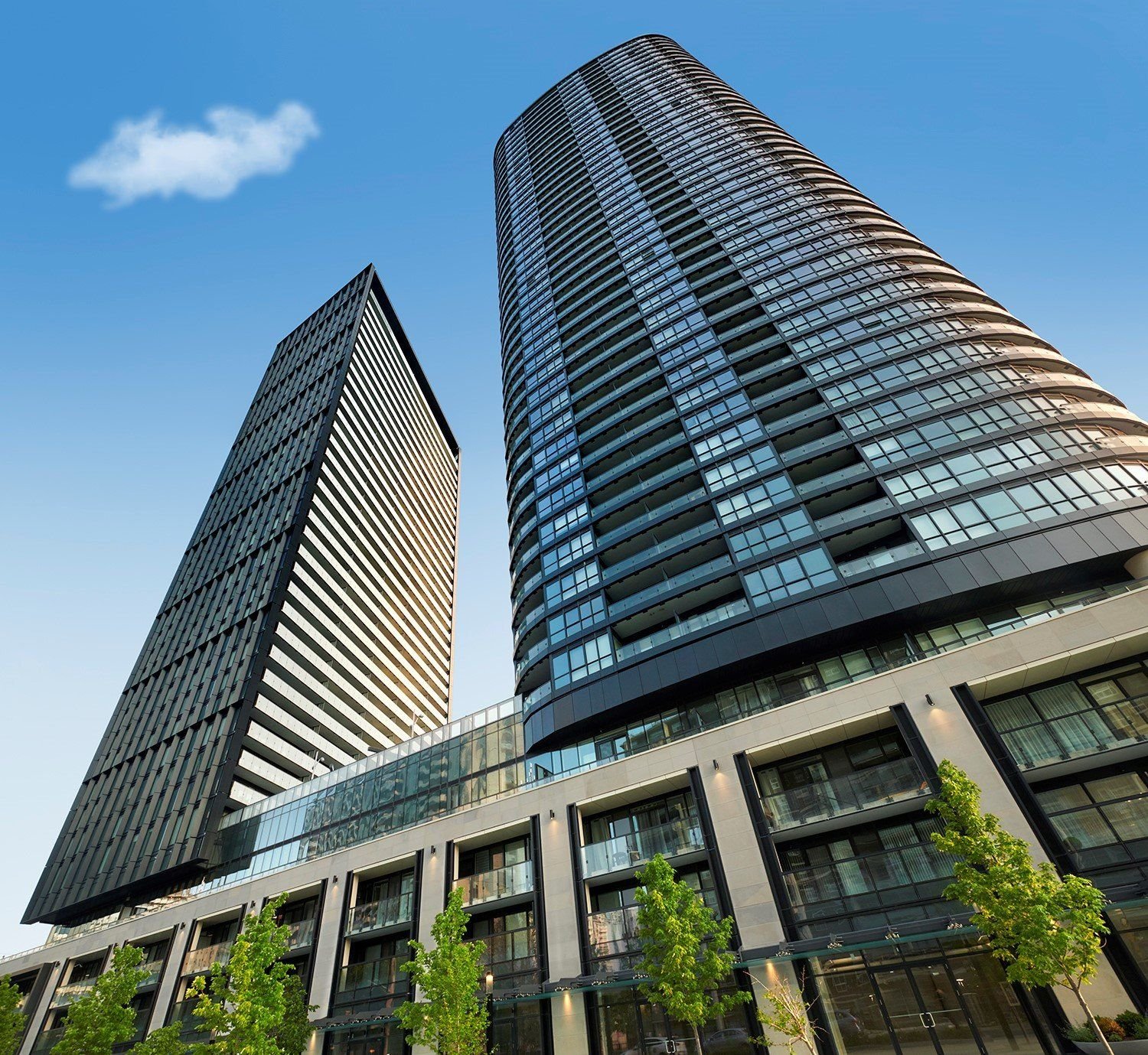 Two dark condo towers seen from street level