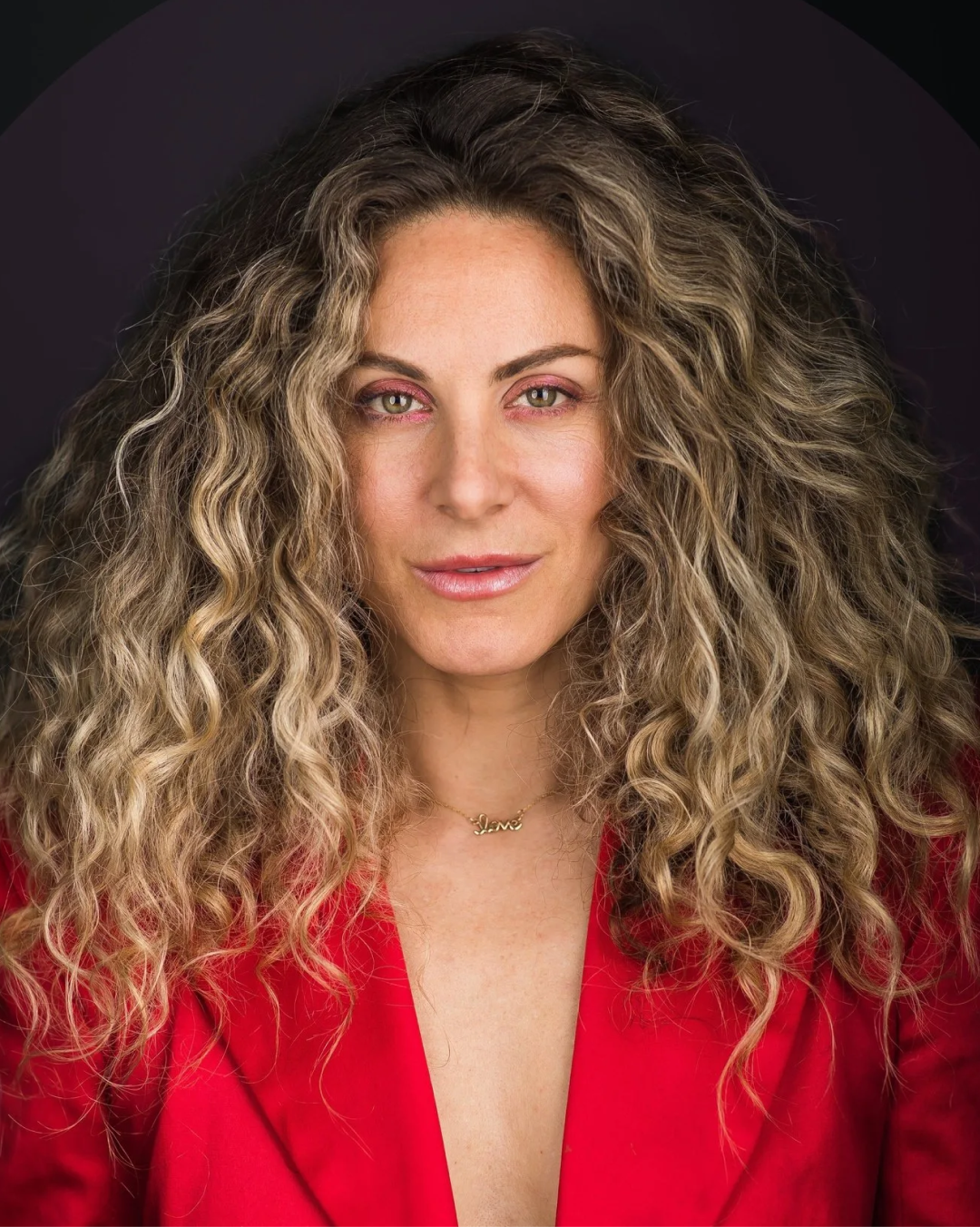 Portrait in a red blazer against a dark backdrop
