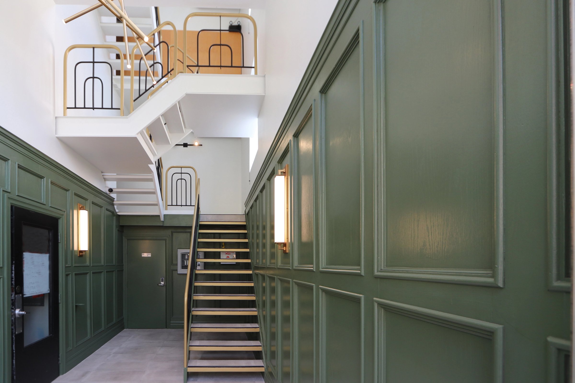 Green panelled hallway with a staircase