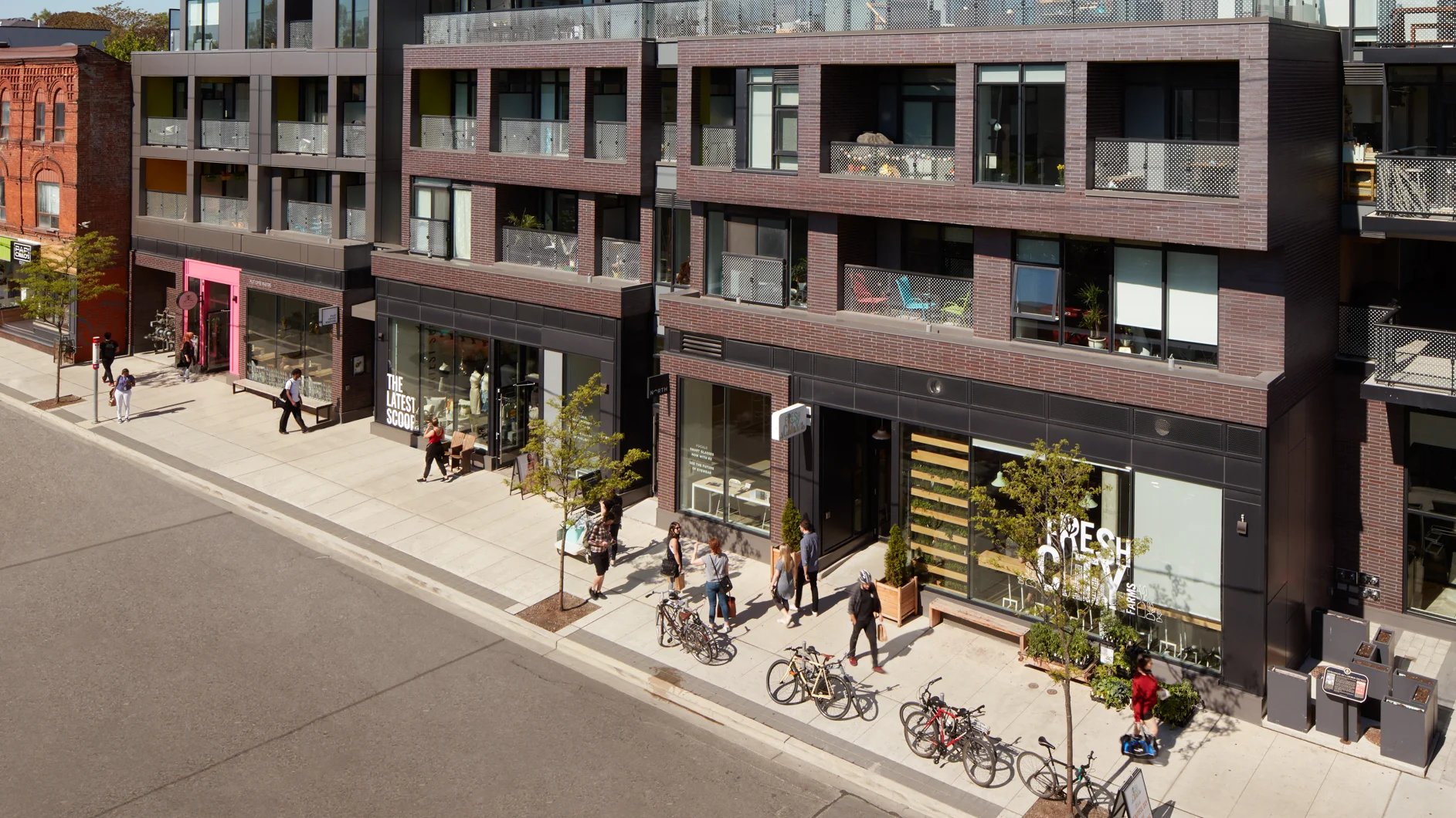 Street-level retail below dark brick condo units