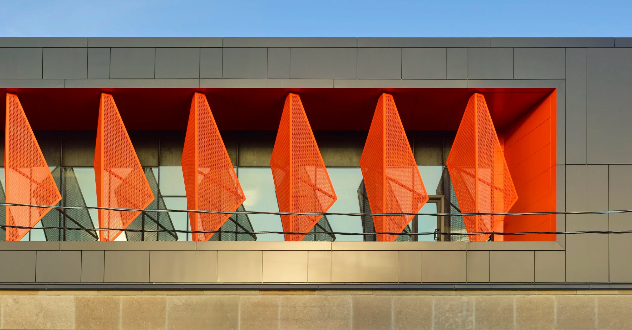 Orange folded metal fins over a glass band