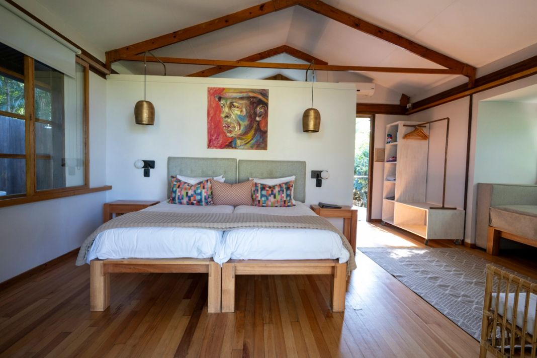 A second view of a suite bedroom, from the window seat toward the bed.