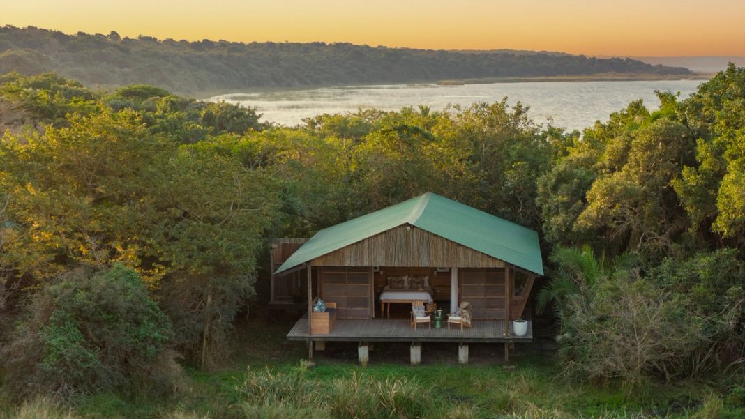 The honeymoon suite opens onto its private deck above the dune forest, with Lake St Lucia stretching to the horizon at dusk.