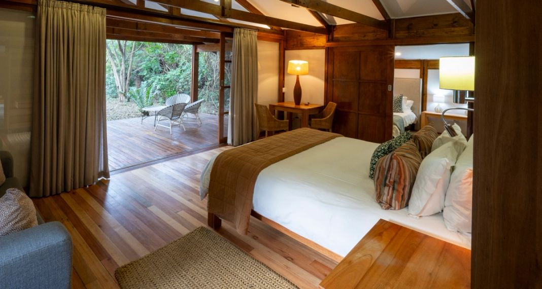 A family room interior with a wide bed and doors to the deck.