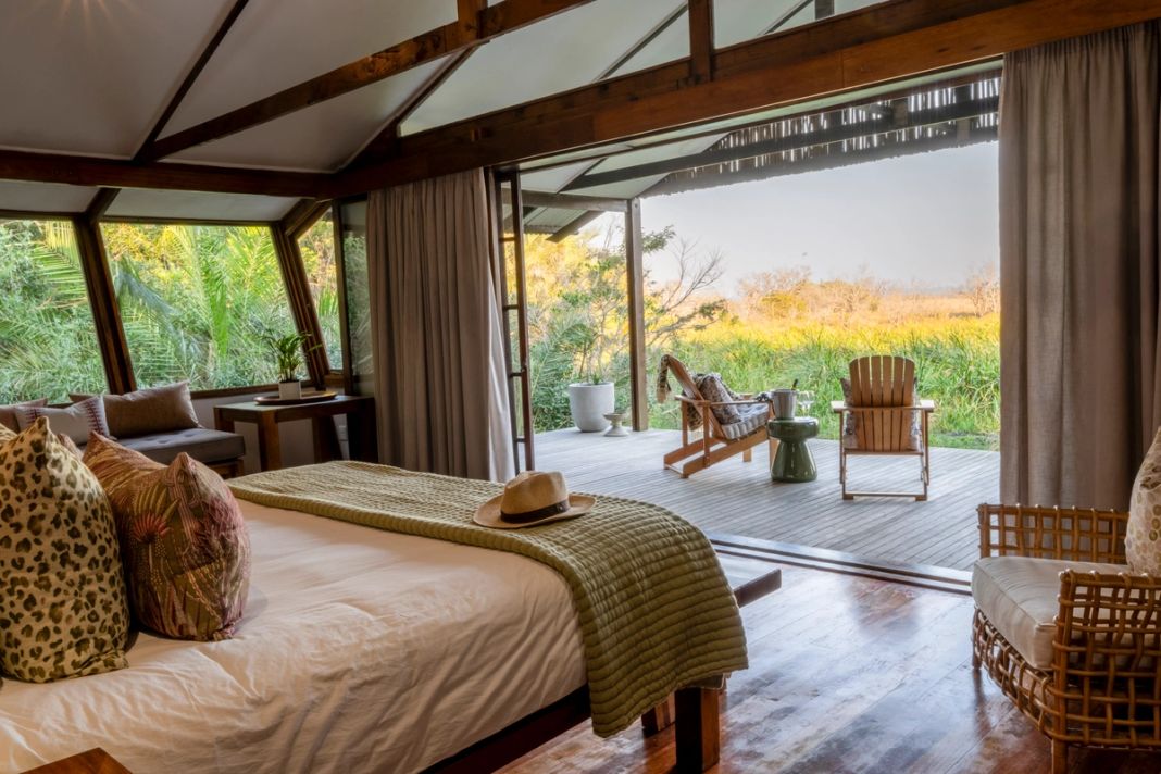 The honeymoon suite bedroom opens onto a private deck with two chairs facing the wetland.