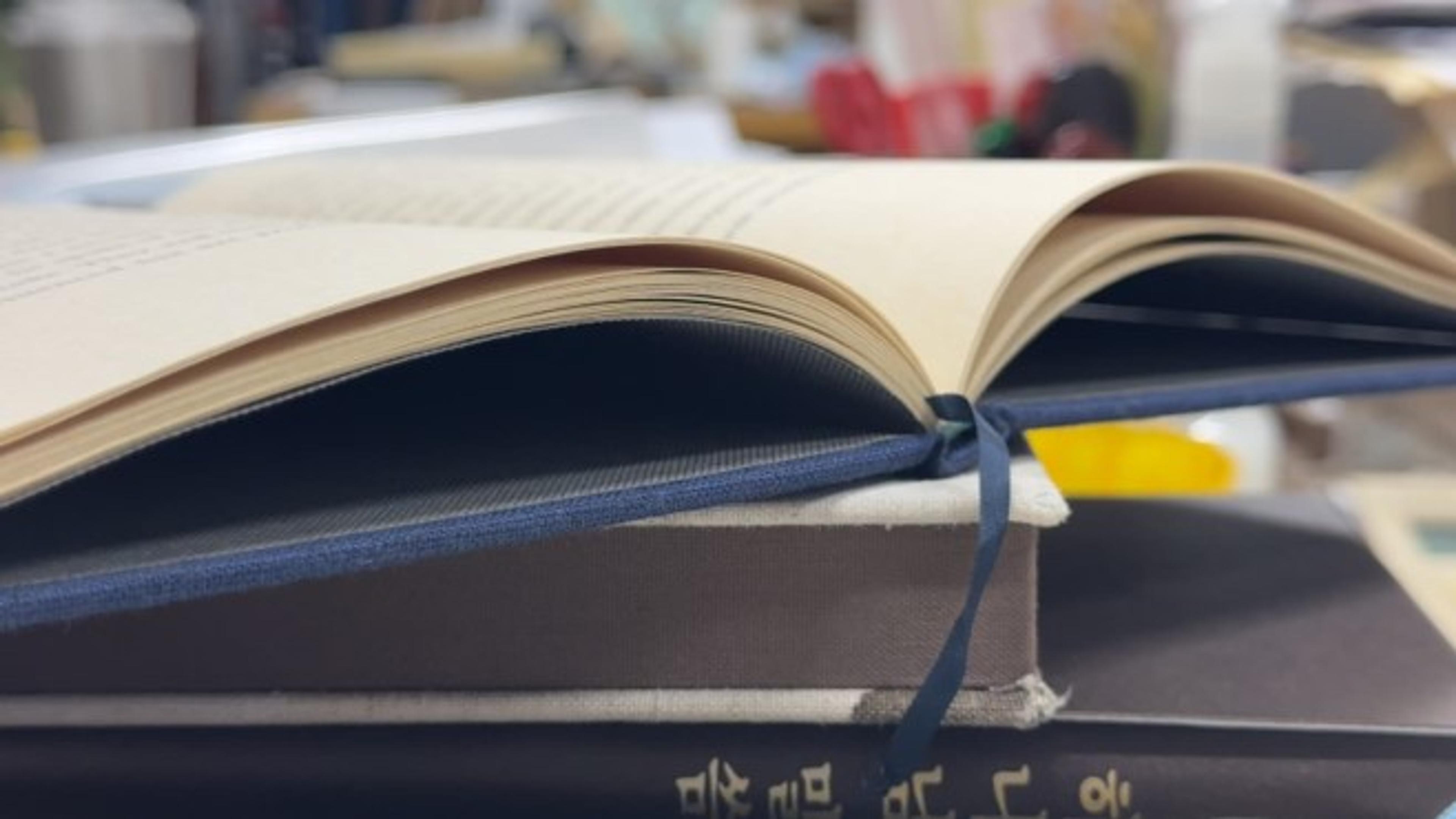 A finished hand-bound book opening naturally at the Marumizu-Gumi studio.