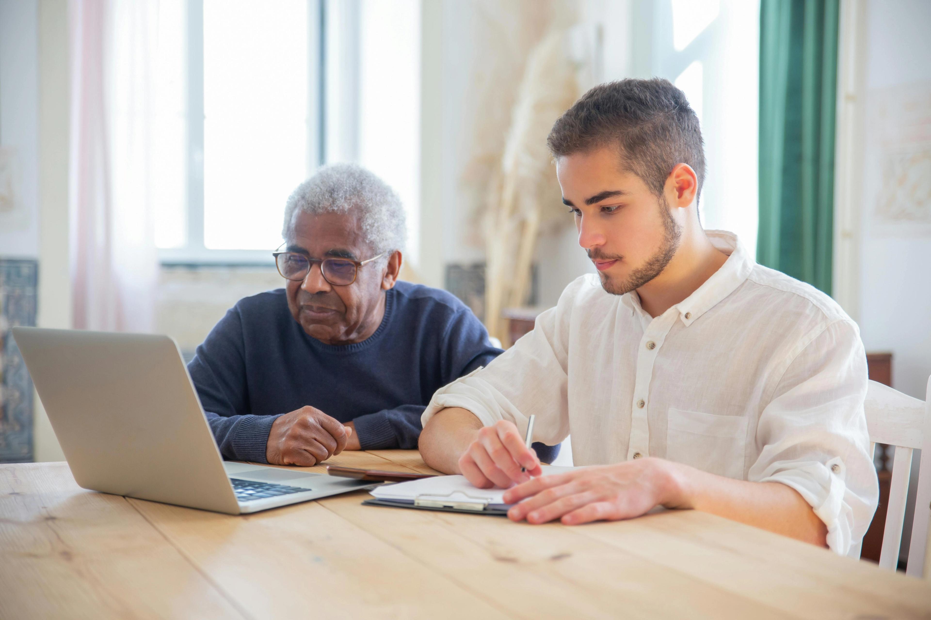 A ghostwriter helping someone write their life story at a desk
