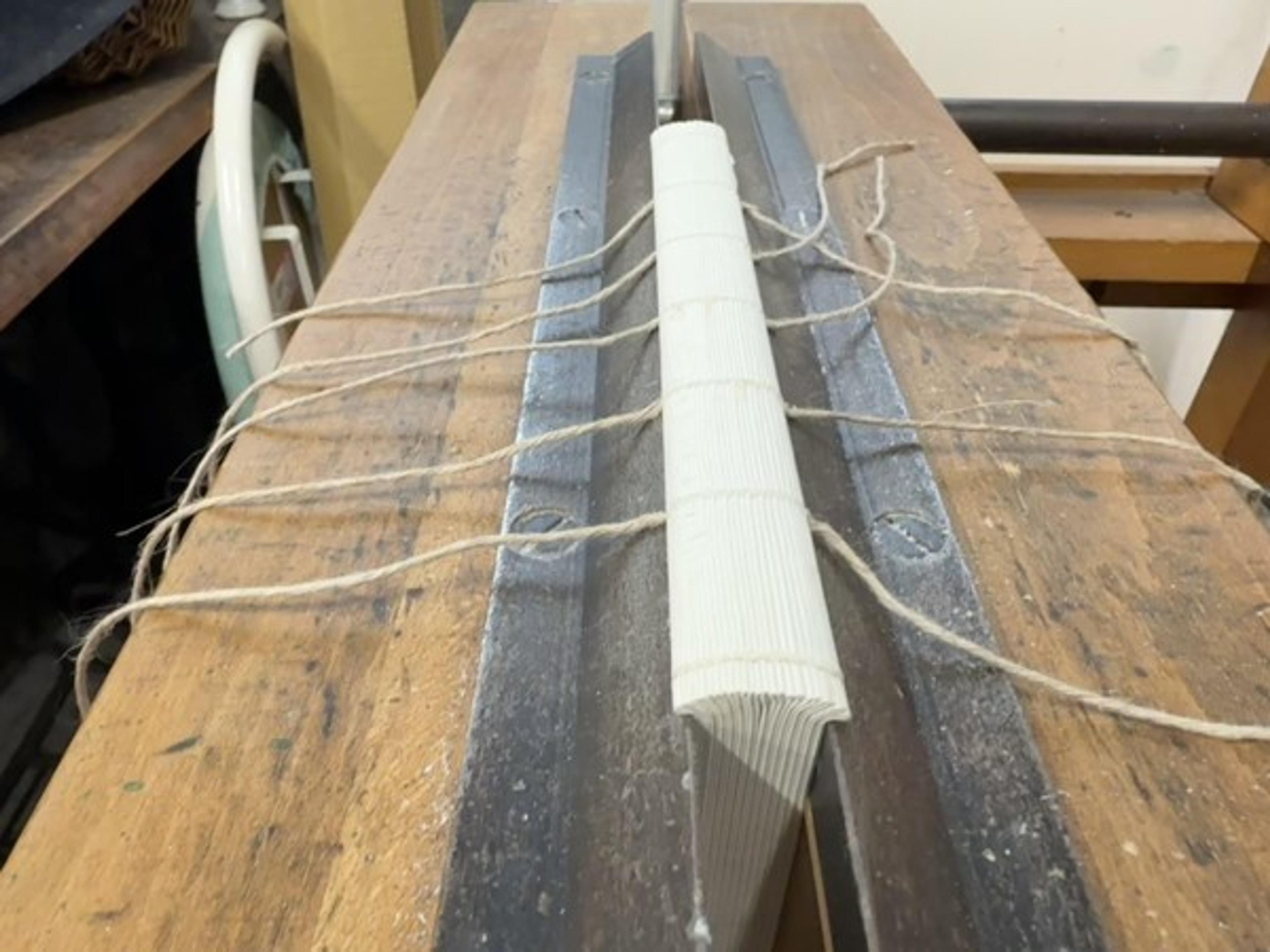 Folded sections are aligned on a sewing frame before they are joined.