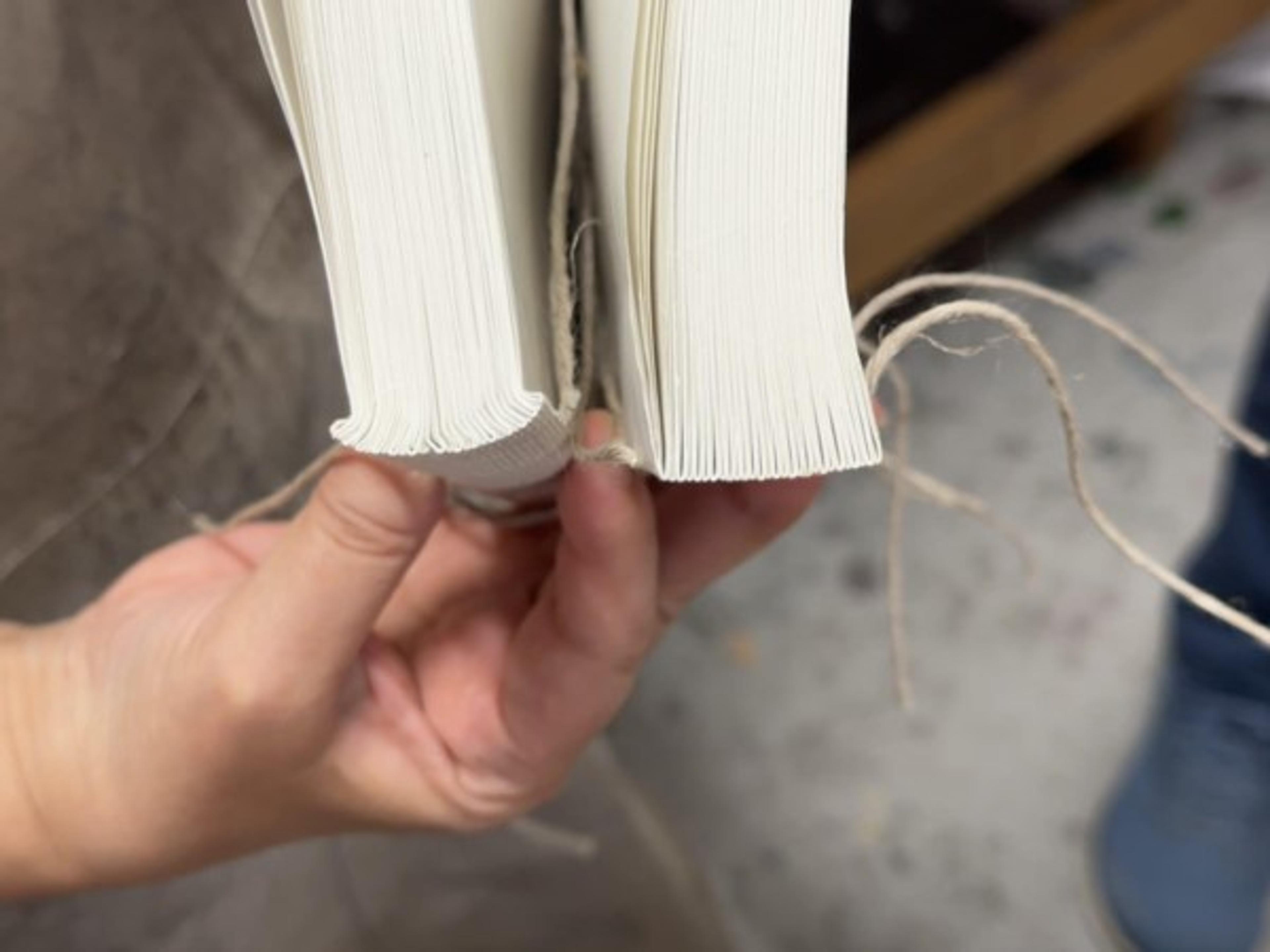 Two sewn text blocks side by side, one rounded at the spine and one left flat.
