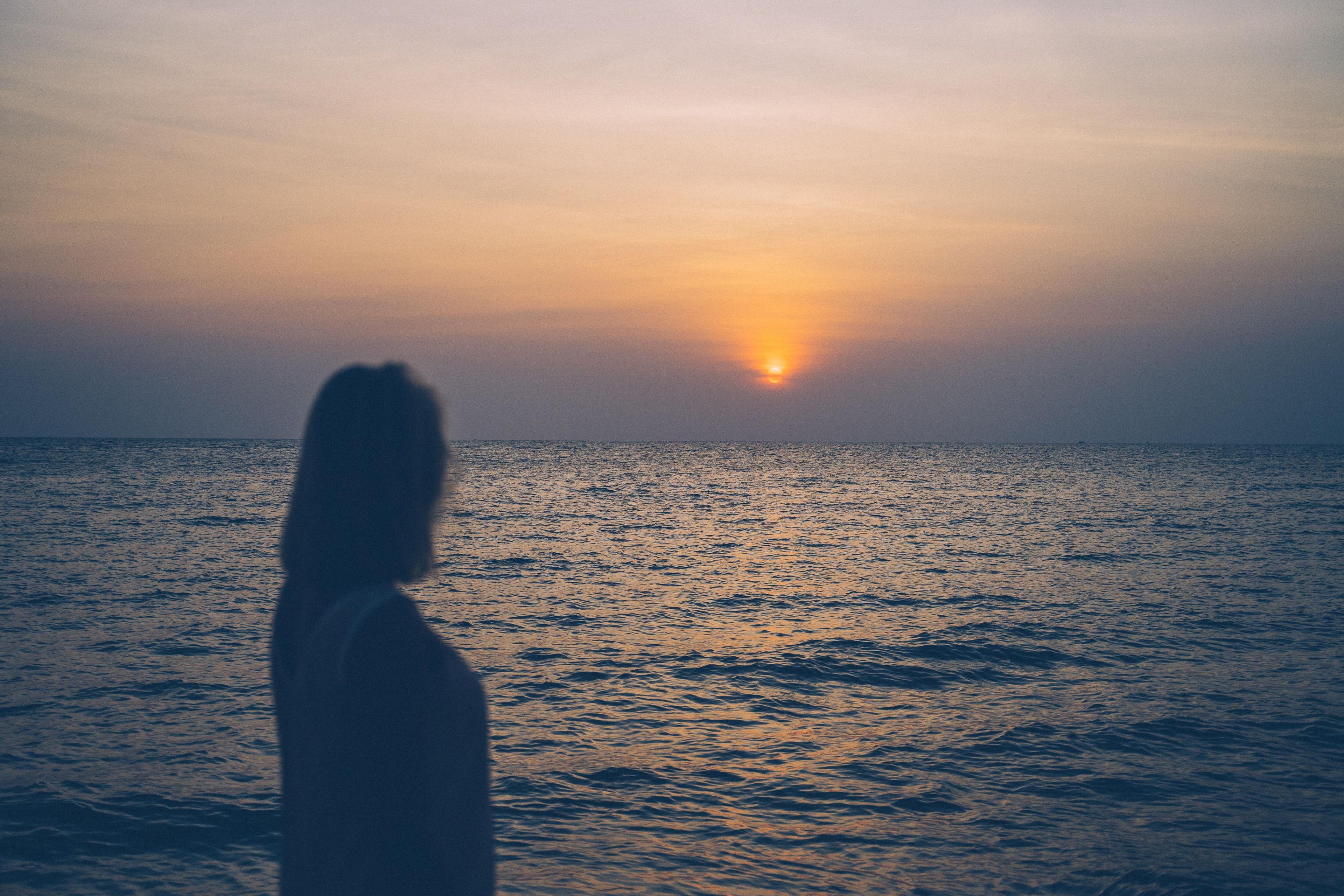 A woman looking out over a sunset