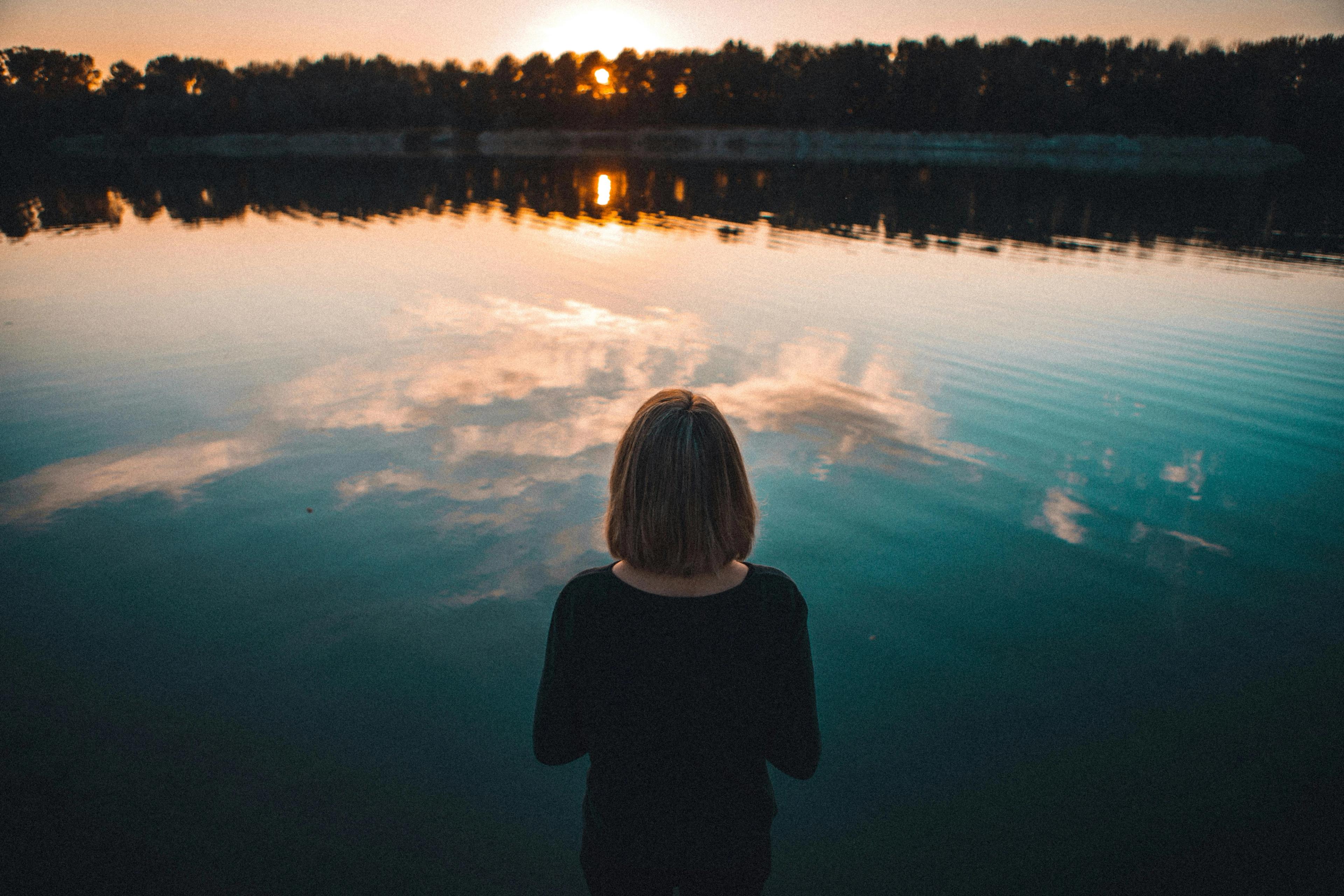 A person reflecting by a lake