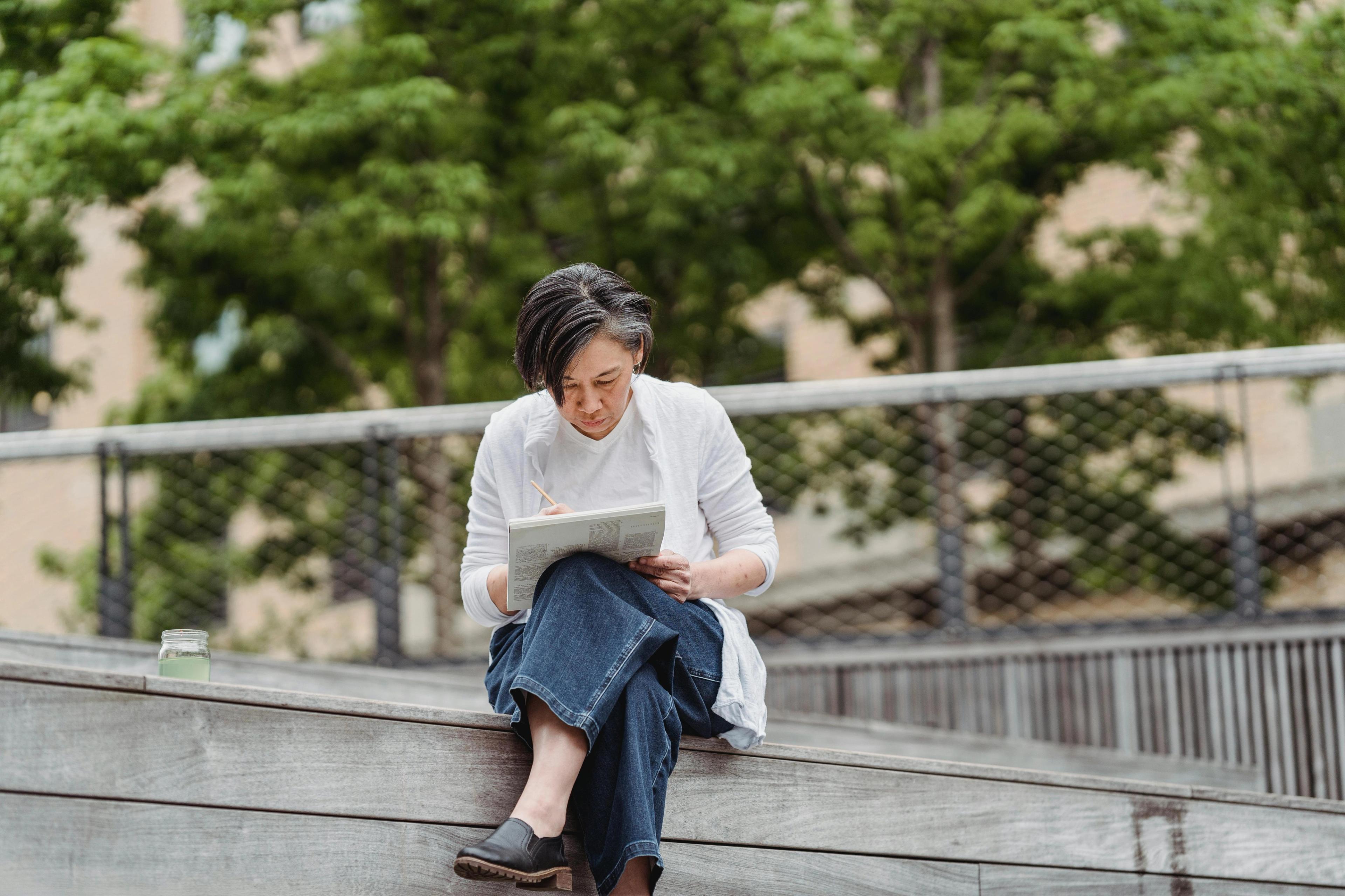A woman writing and reflecting on a street