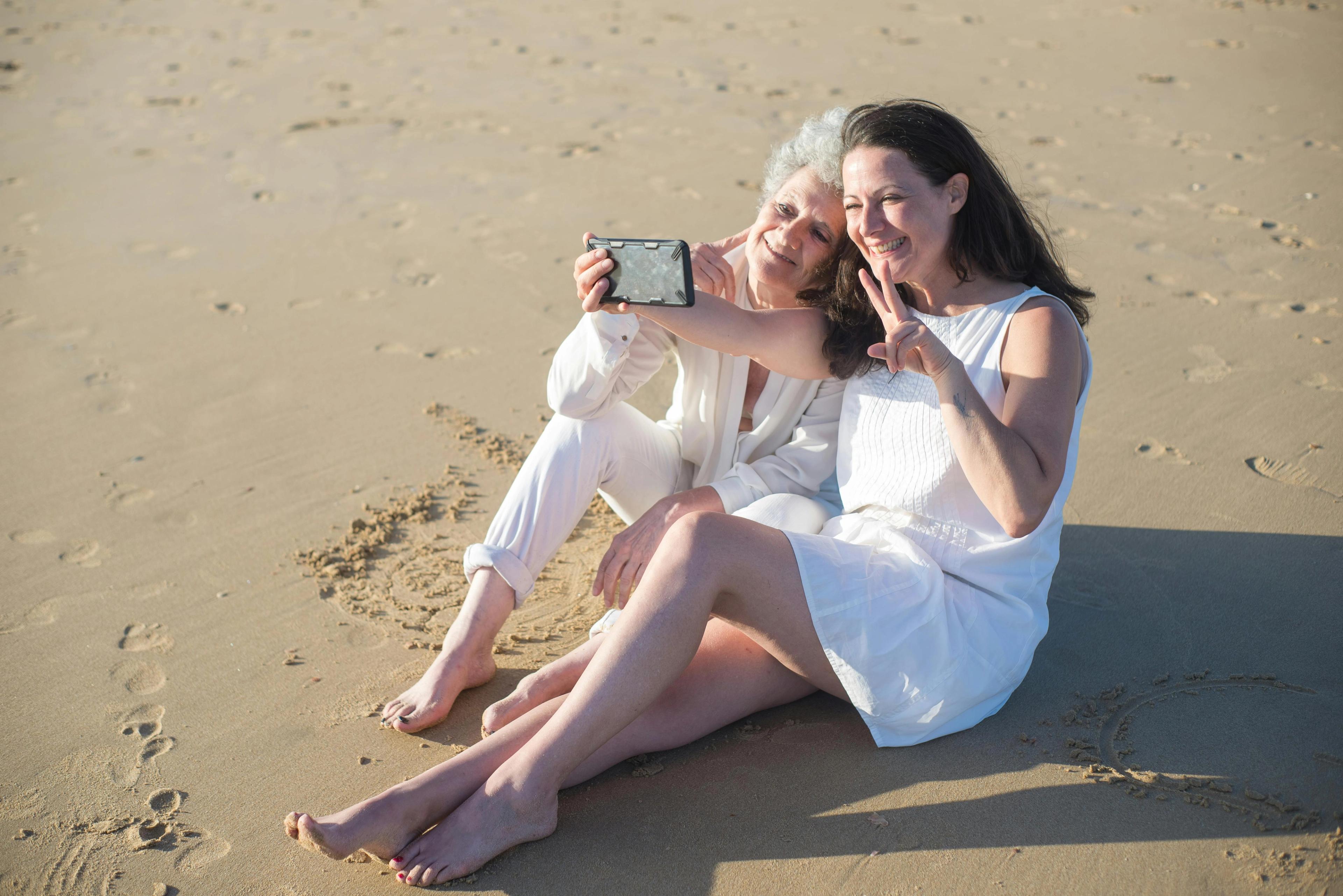 Mom and daughter taking a selfie on a beach