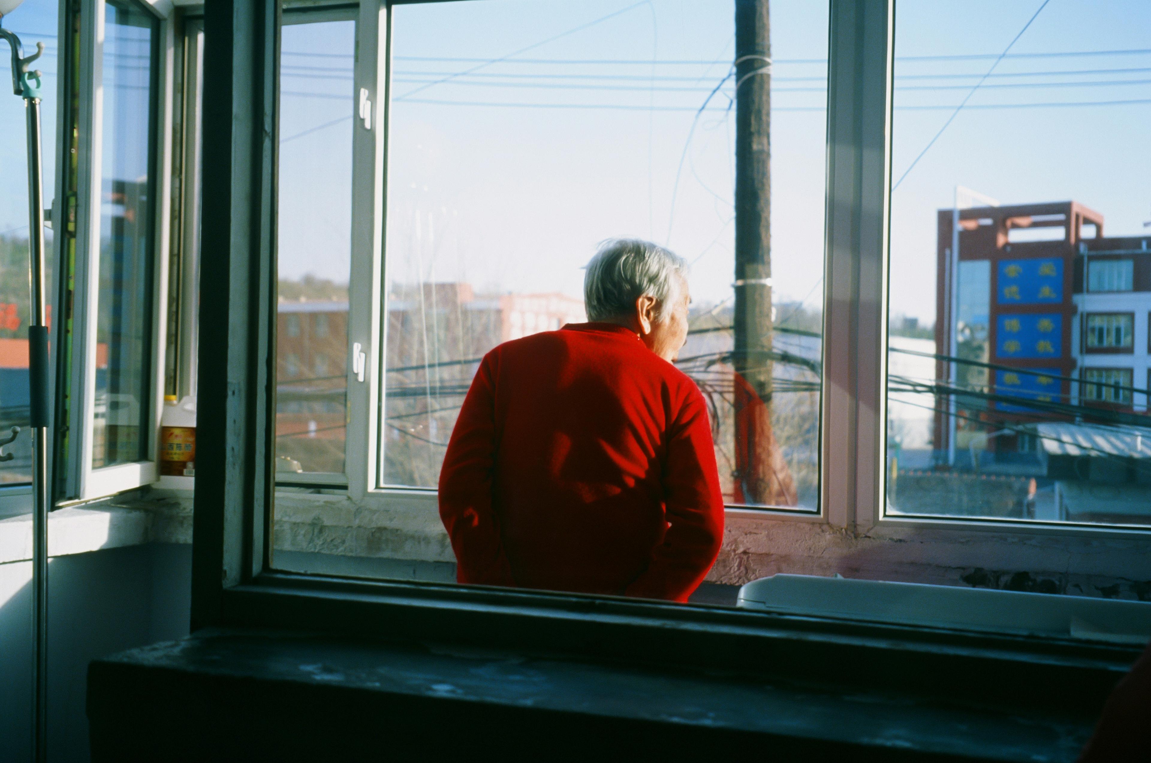 Older person looking out a window
