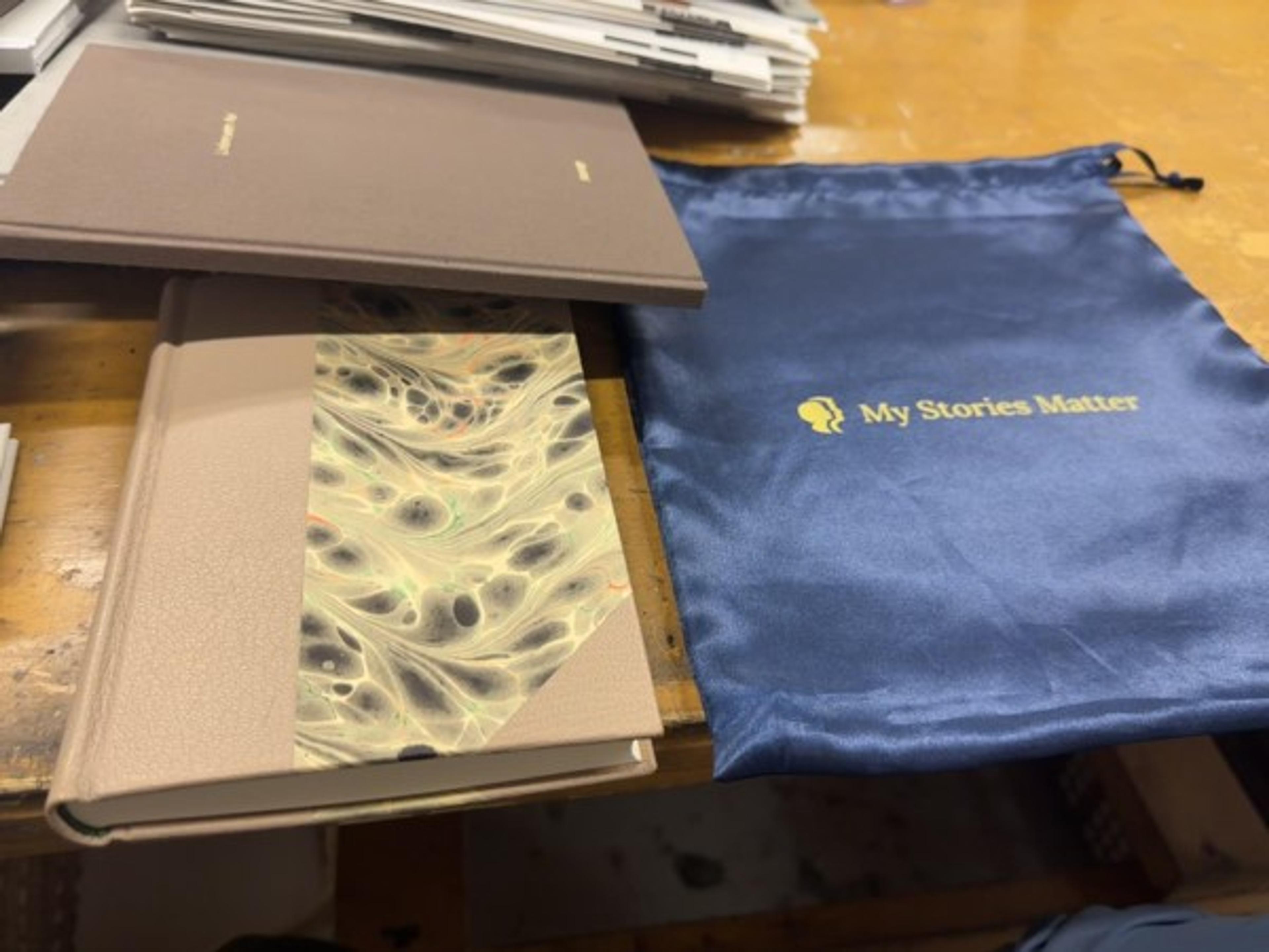 A finished book with a blue My Stories Matter presentation pouch