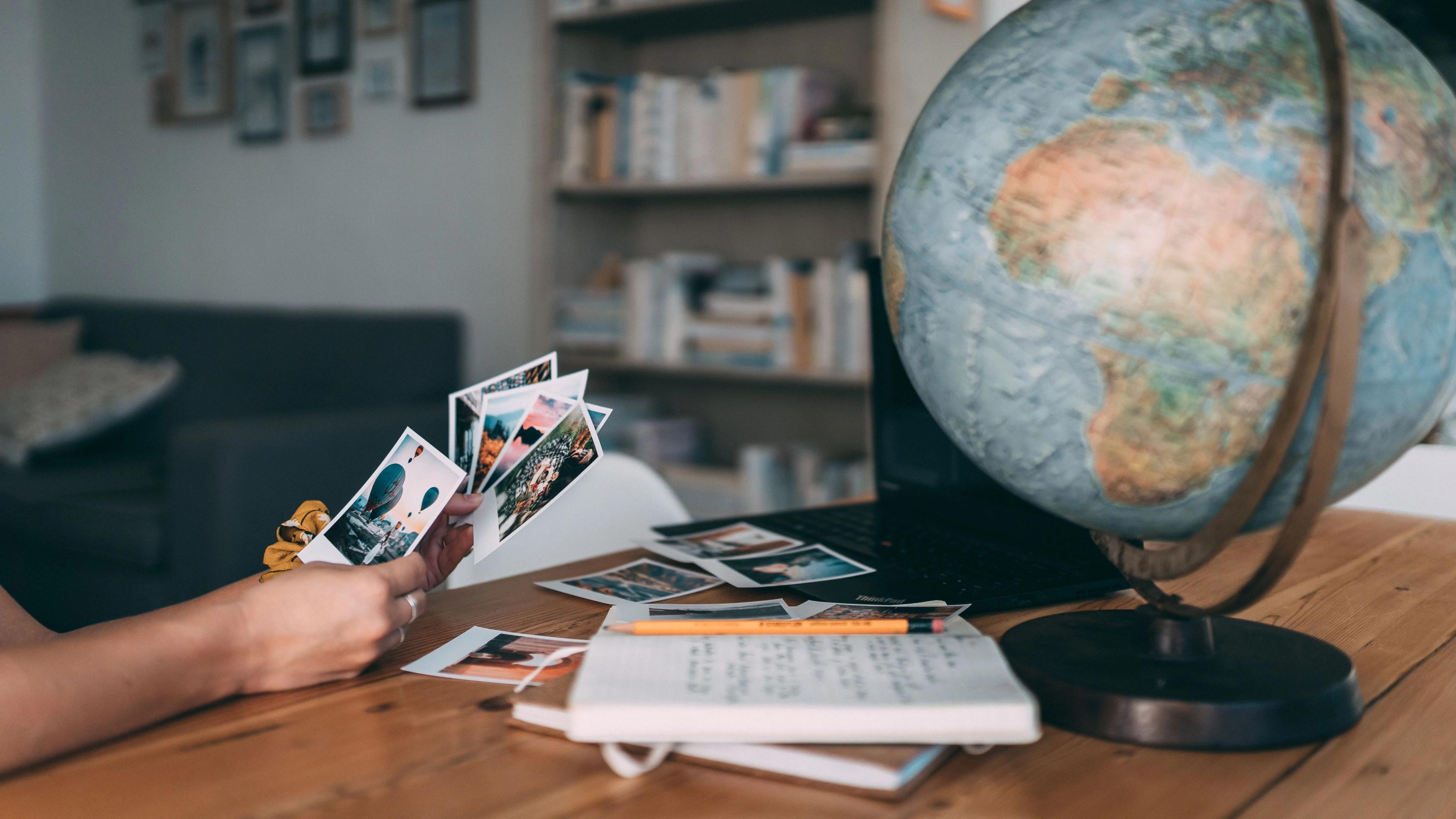 vacation holiday photos on a desk with a globe