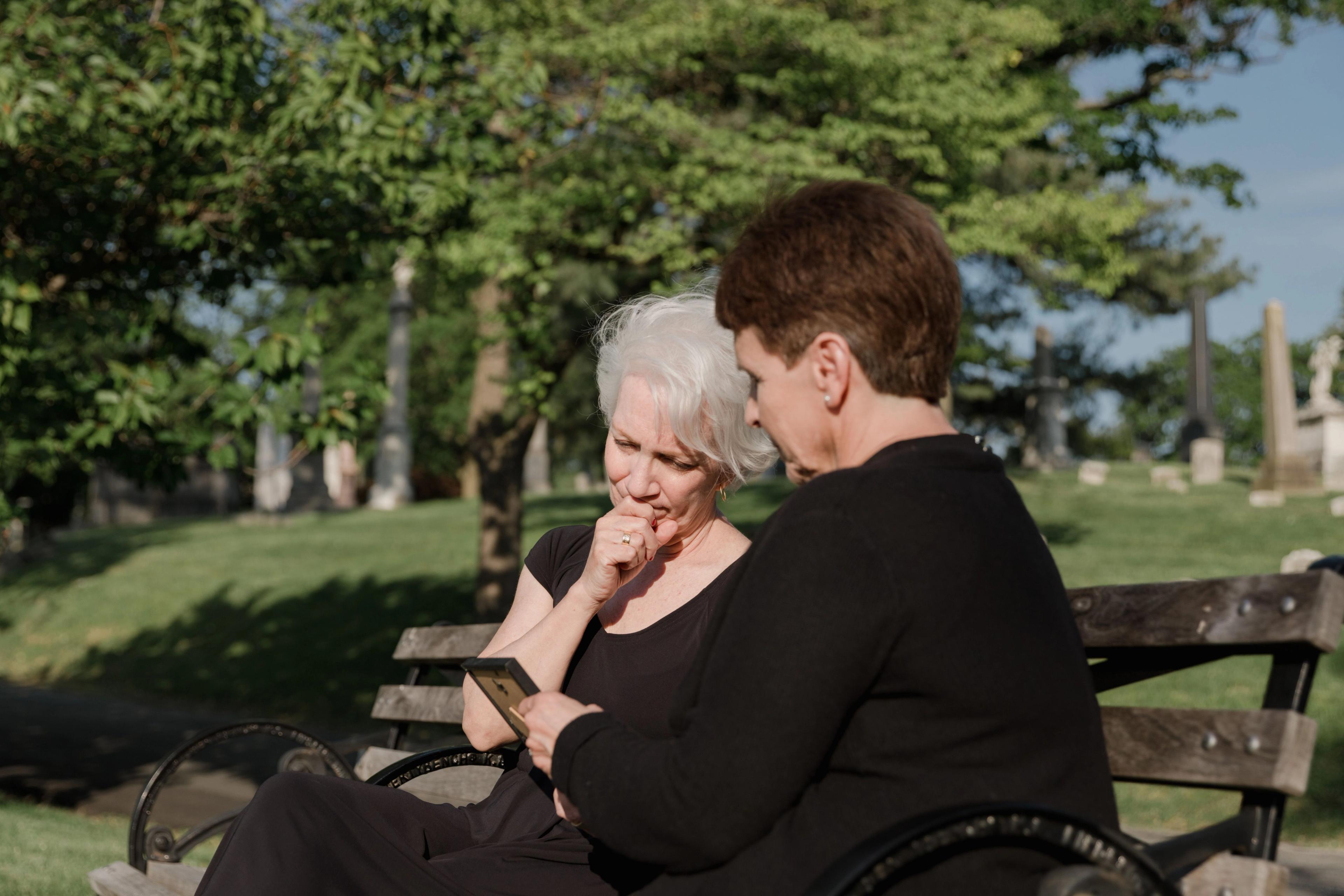 Two women talking looking at a photograph