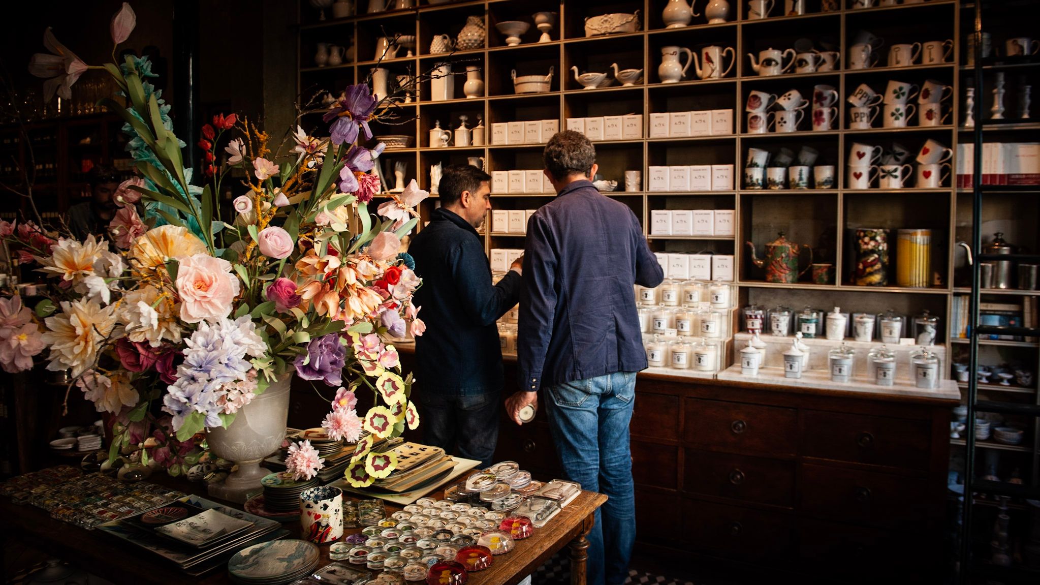 Interior of the Astier de Villatte Paris shop, shelves of white ceramics and paper flowers